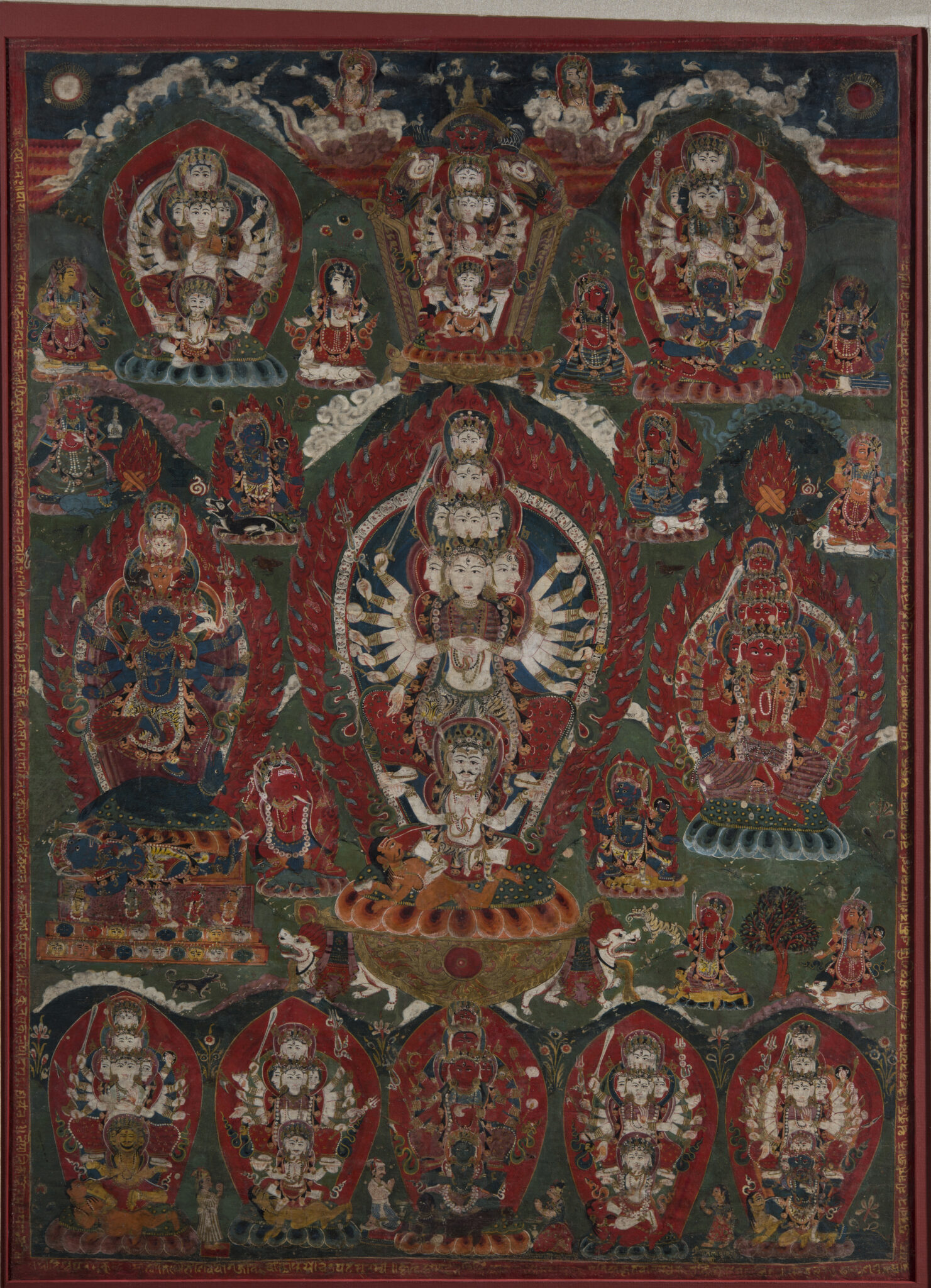 Many-armed and -headed wrathful goddess at center flanked by deities, each framed by fiery nimbus