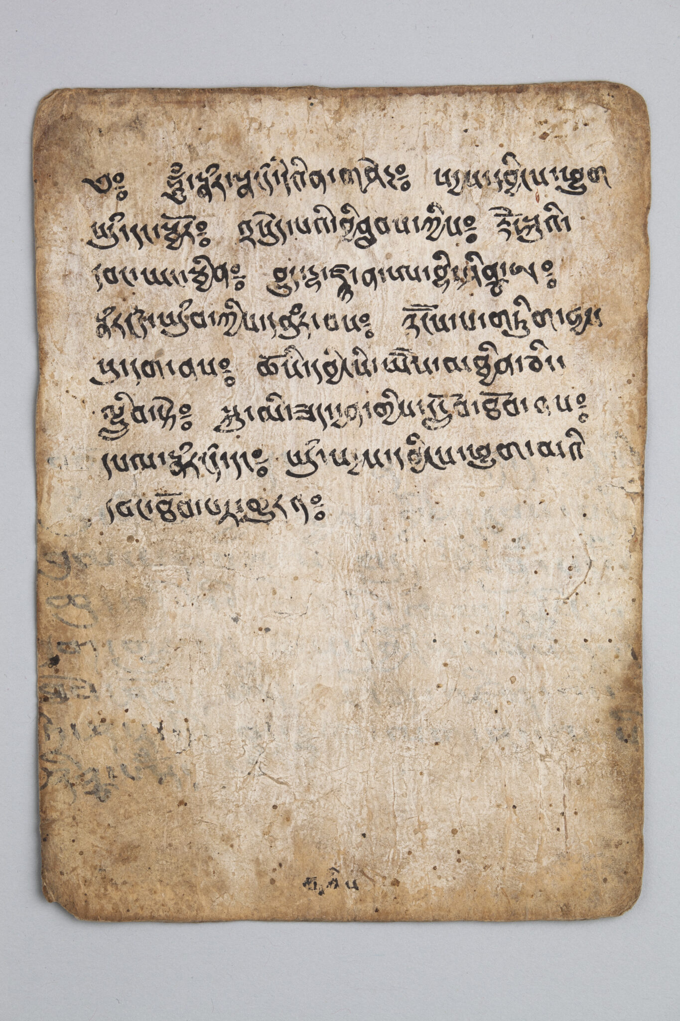Rectangular tea-brown page, edges and corners darkened, with eight lines of text covering top half