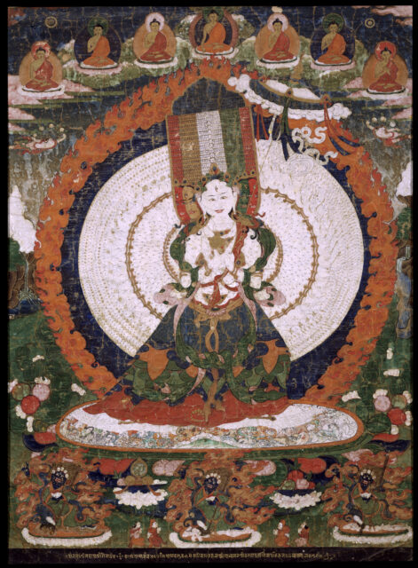 Deity wearing sumptuous red, green, and blue skirt holds white parasol before white disc and fiery nimbus