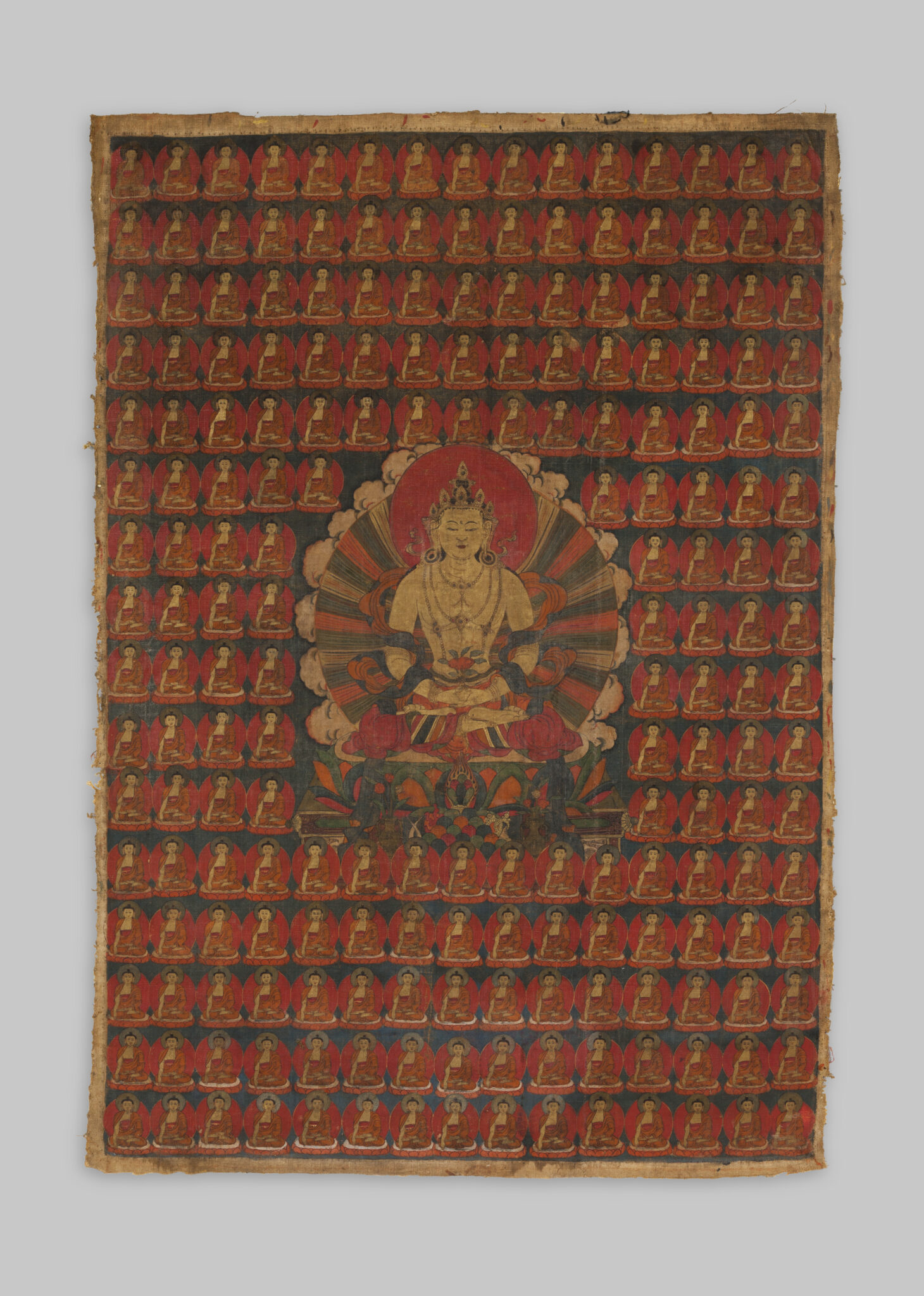 Painting in reds and golds depicting Buddha seated in meditation amidst grid of dozens of miniature portraits