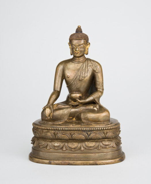 Brass-colored statue depicting Buddha seated in meditation, holding bowl in lap and implement in extended left hand