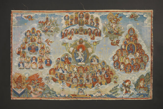 Three clusters of portraits centered on white-skinned deity in dancing pose hover above mountainous landscape