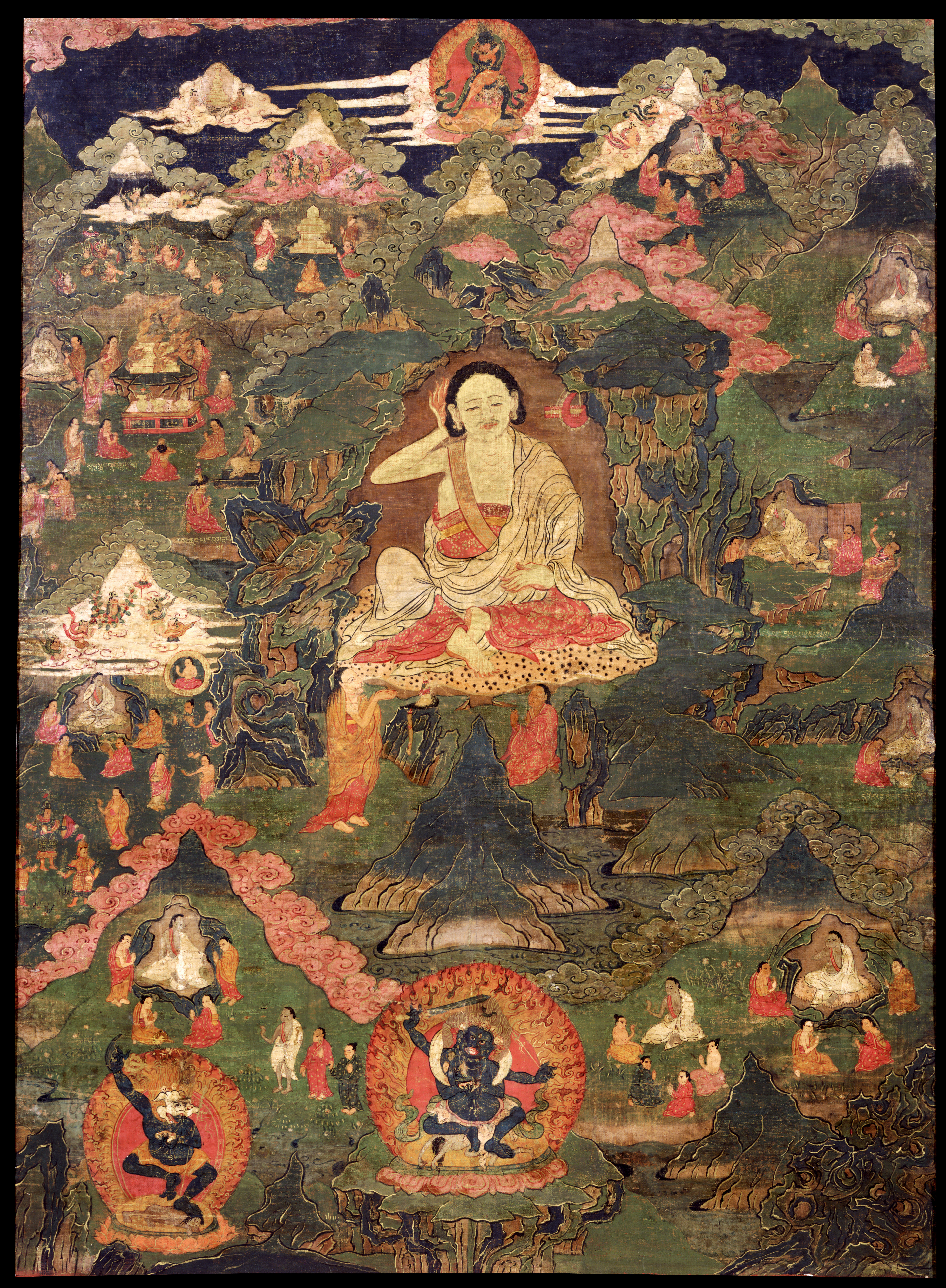 Siddha holds left hand to back of head as he floats above rocky landscape dotted with buildings and groups of figures