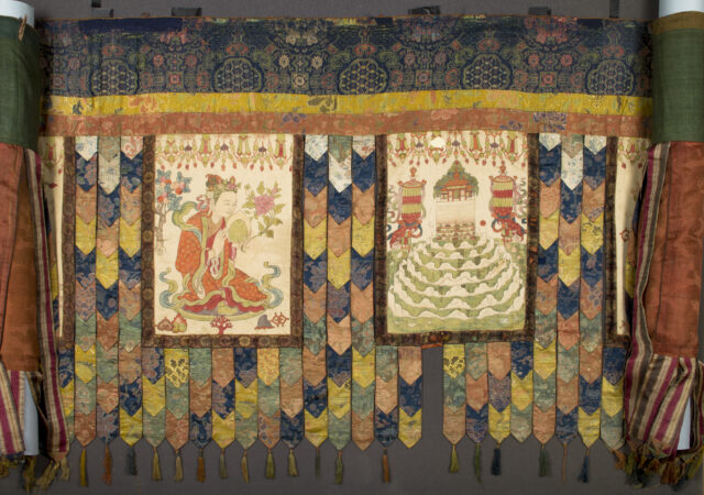 Colorful banner made of chevron-shaped pieces of textile supporting two paintings depicting woman at left, religious structure at right