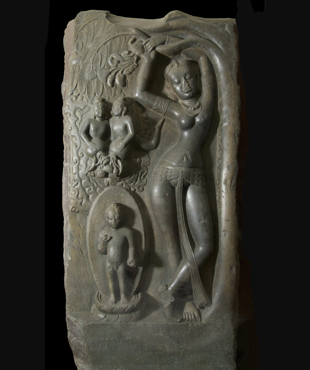 Relief in green-grey stone of woman grasping tree branch and swooning as she gazes upon child enclosed in full-body halo