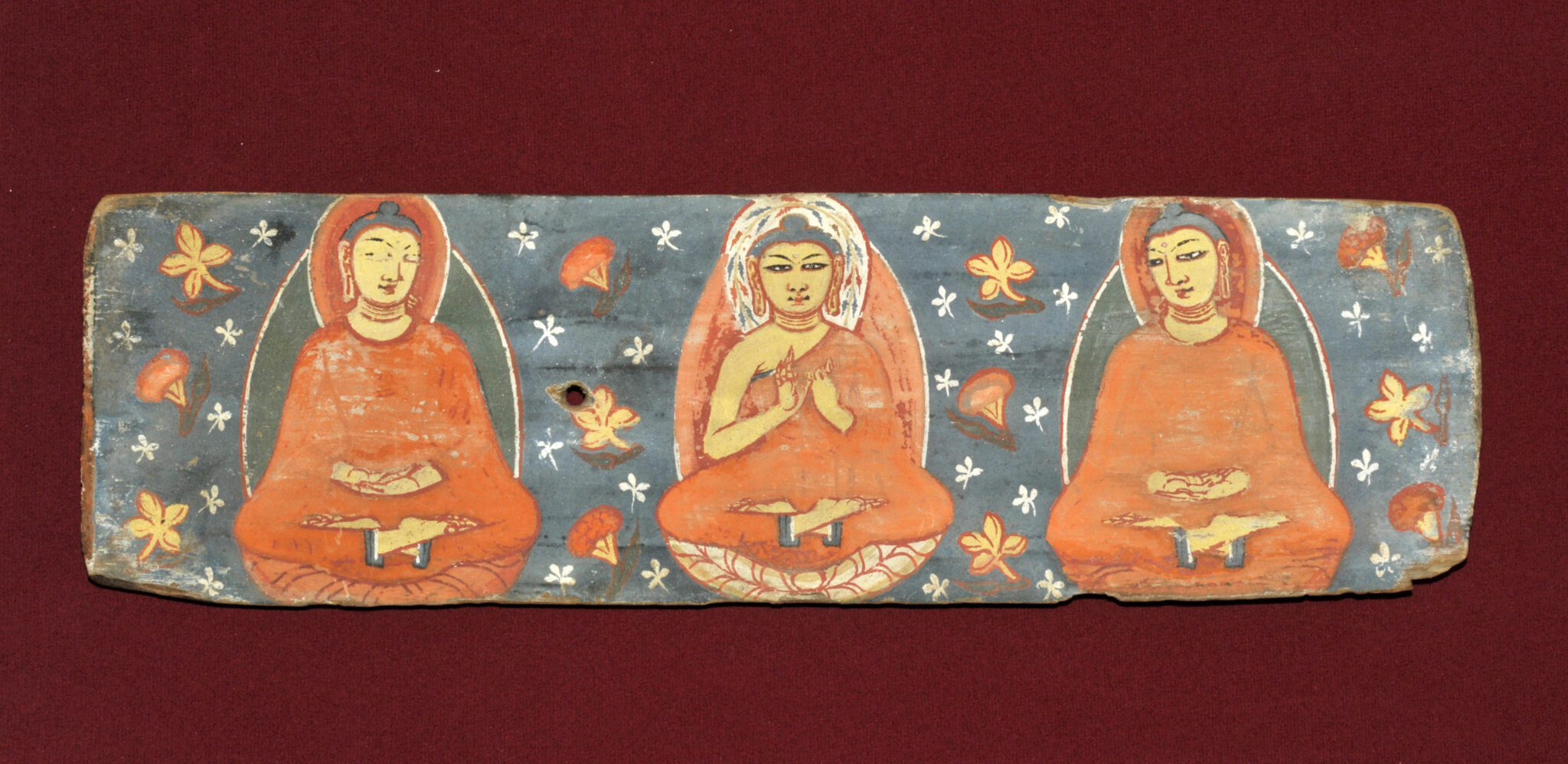 Painting on rectangular panel of two Bodhisattvas facing two worshippers seated against blue background with floral motif