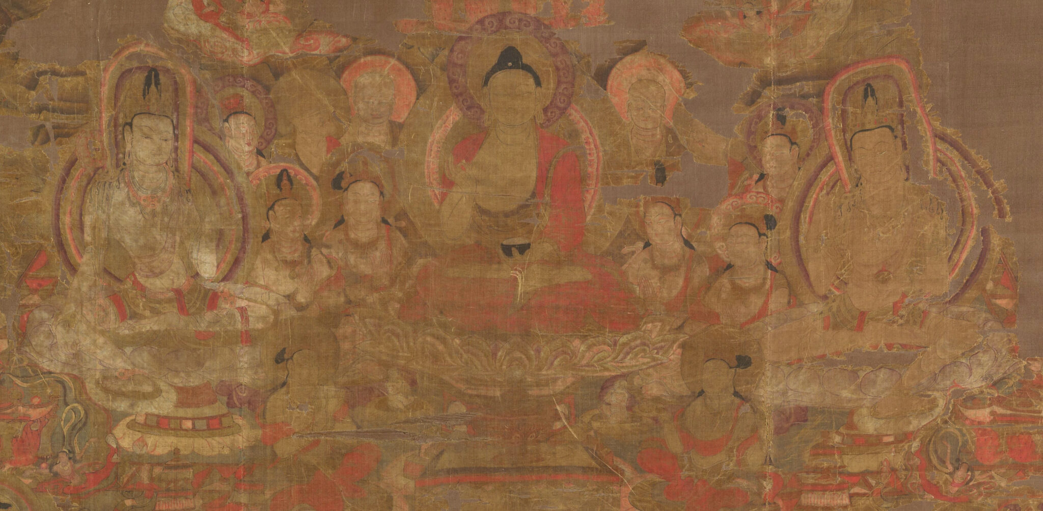 Detail of painting in oranges, reds, and yellows depicting three deities seated on pedestals in front of attendants