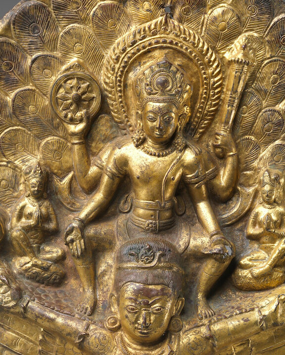 Close view of Vishnu astride Garuda, flanked by smaller deities, holding wheel, club, and shell in three of his four hands