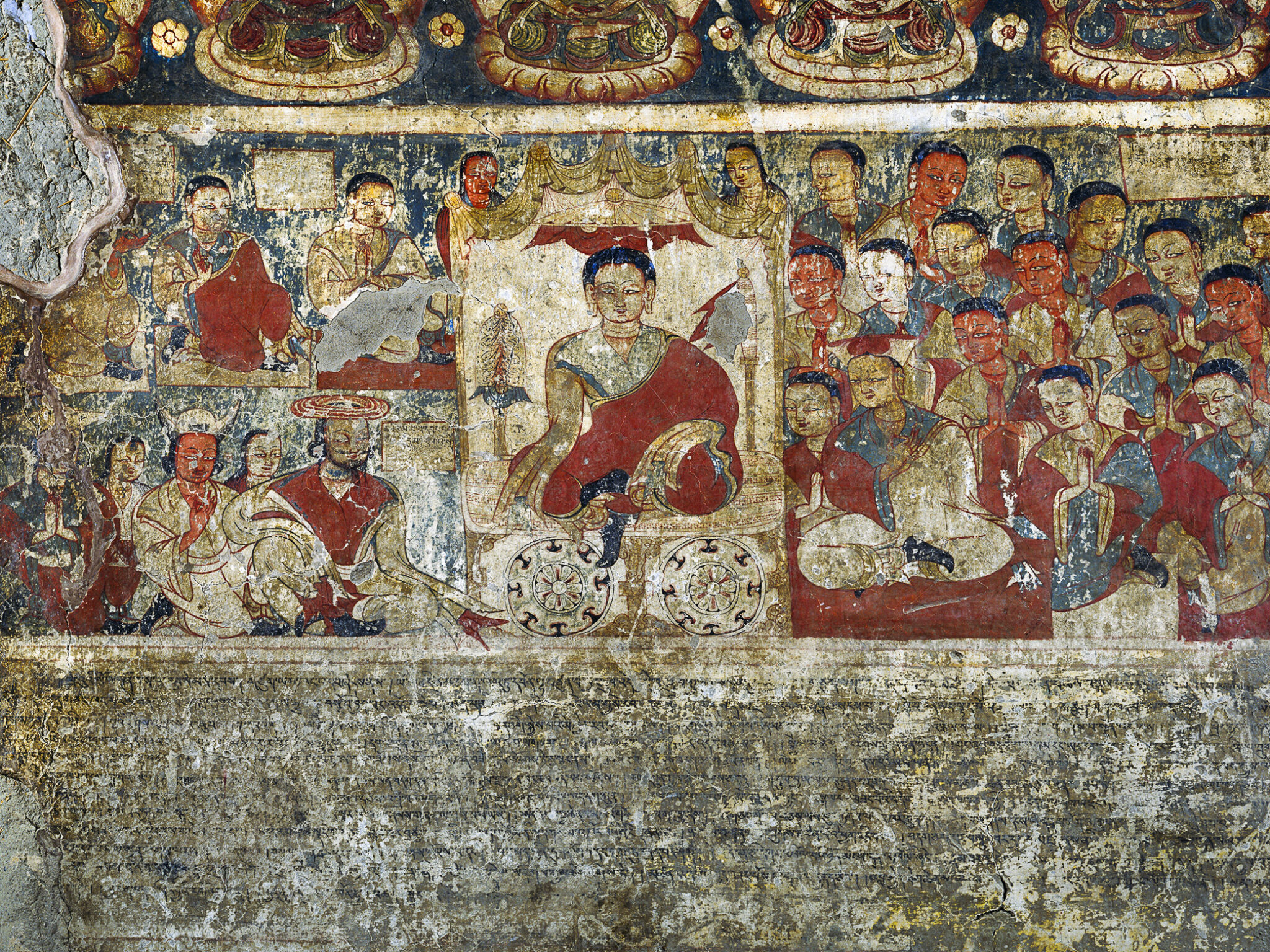 Chipped mural depicting seated robed figure surrounded by profusion of smaller figures above horizontal inscription