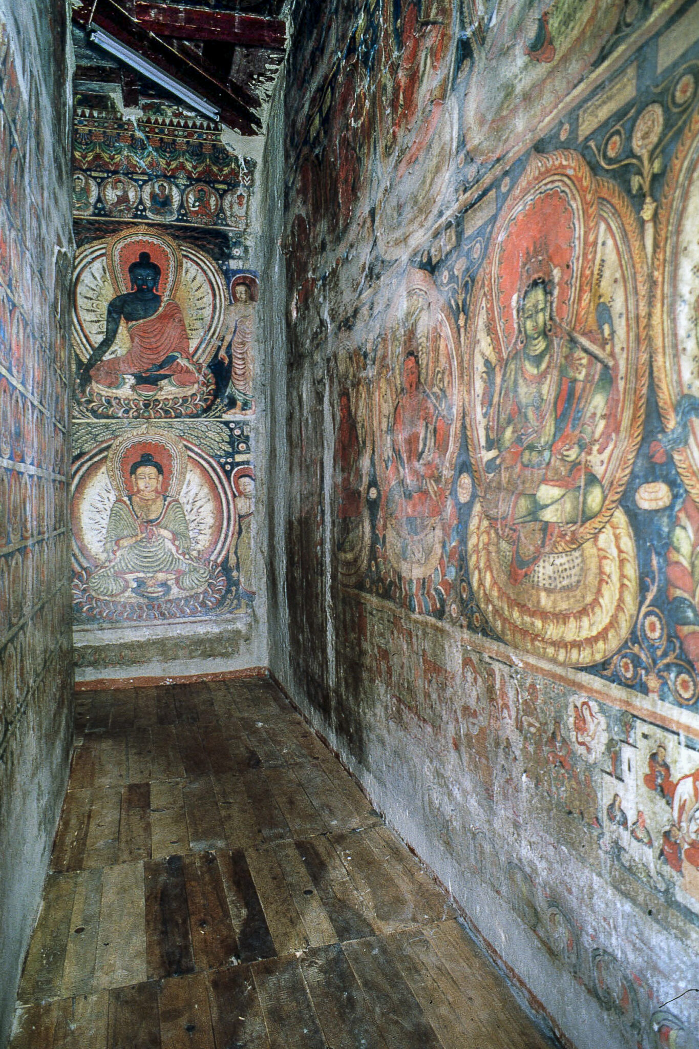 Corridor-like structure with walls entirely covered in murals arranged in registers and depicting deities