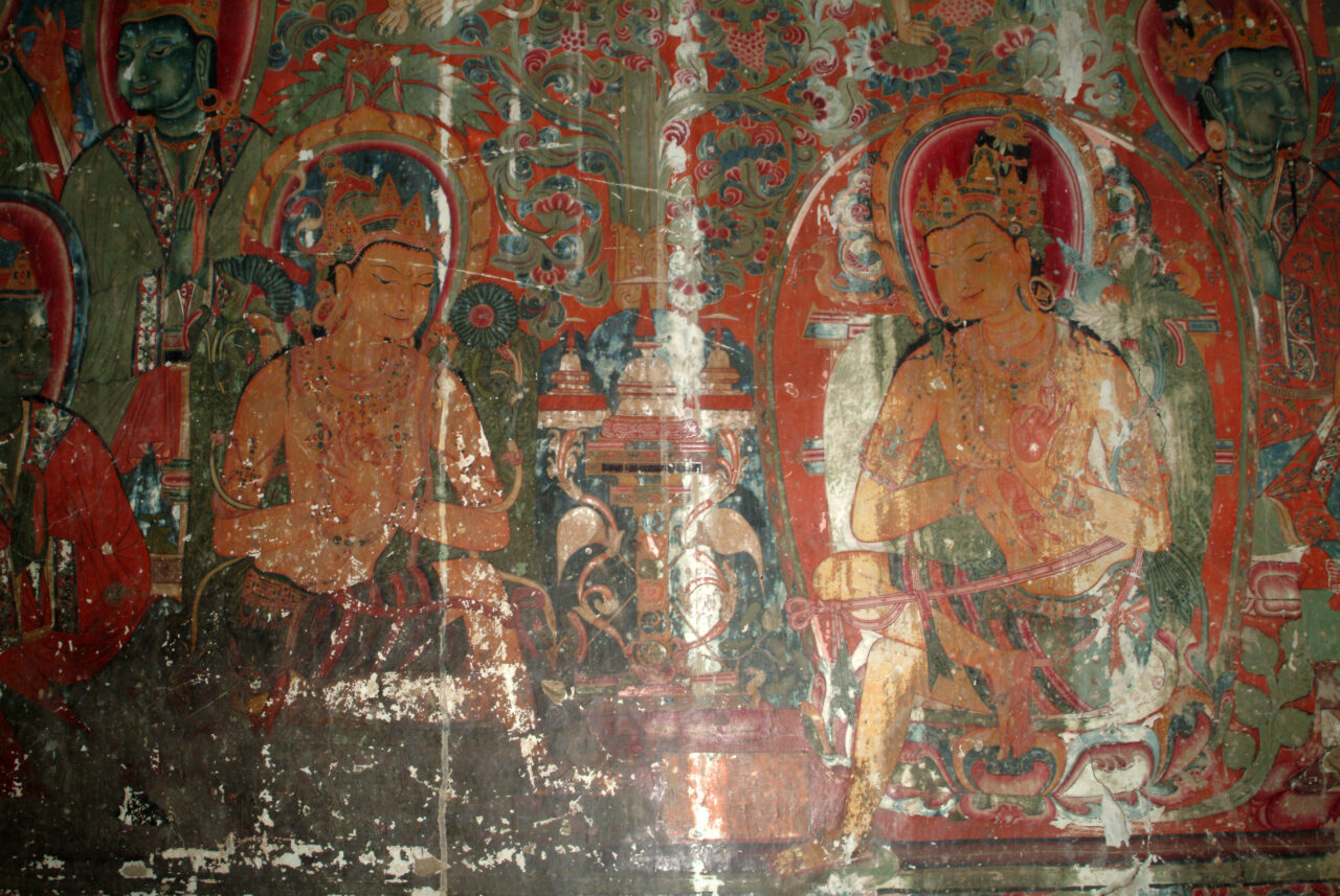Mural in reds, yellows, and greens depicting two bodhisattvas facing one another before tree and attendants