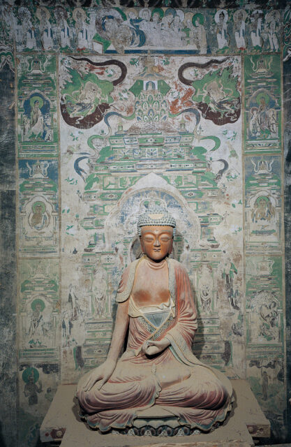 Buddha statue seated before mural in mint-green featuring tiered architectural structure and deity portrait frame