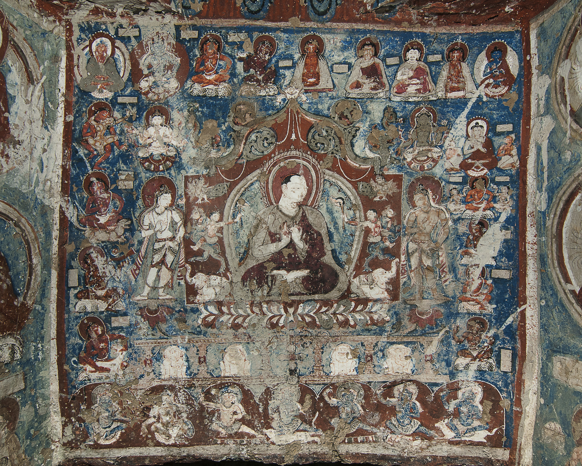 Mural depicting holy man surrounded by dozens of figures arranged in registers against blue and red background