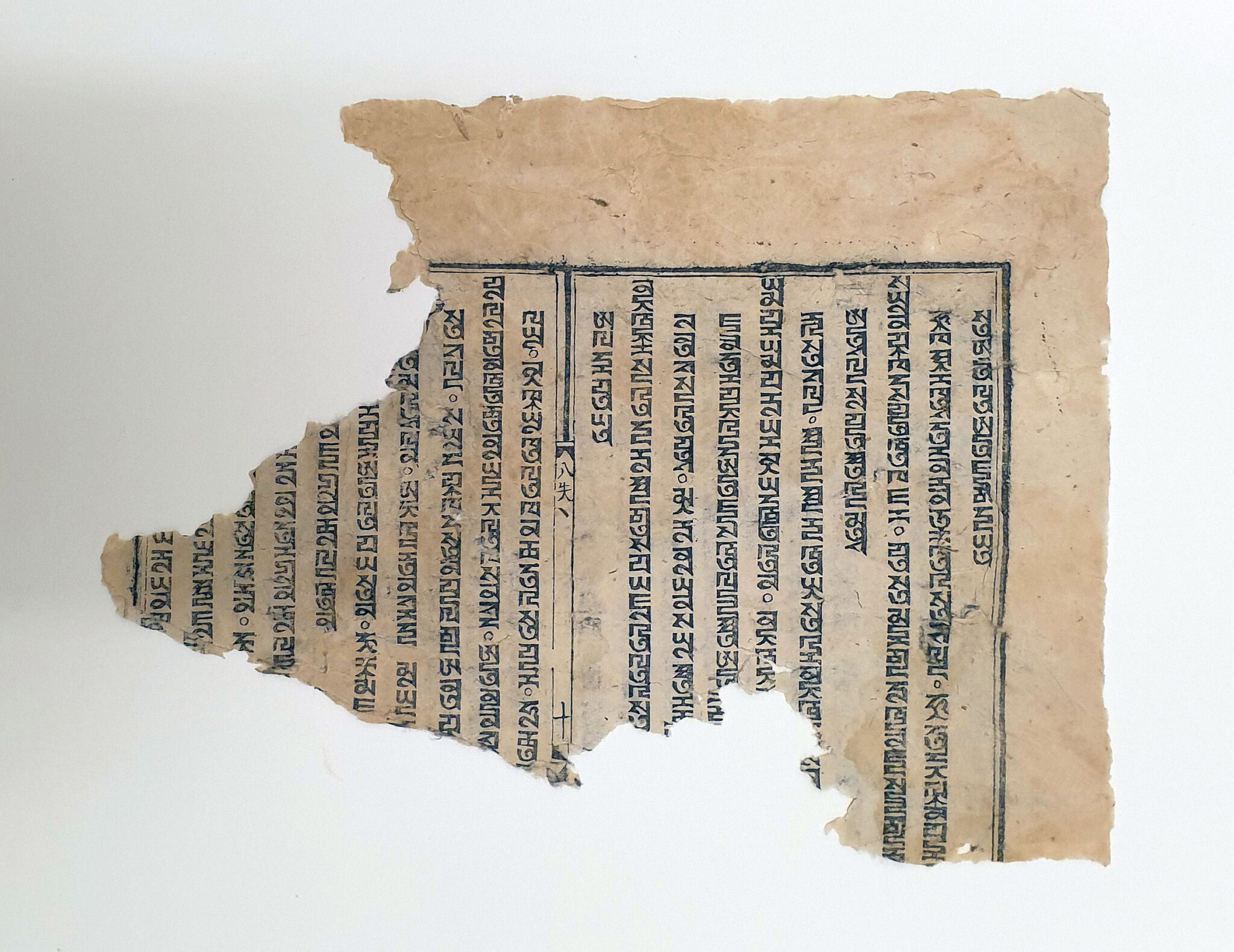 Fragment of page featuring vertical lines of Mongolian script framed by black border on light brown paper