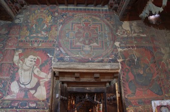 Mural program featuring mandala above lintel and two fearsome deities before fiery nimbuses flanking doorway