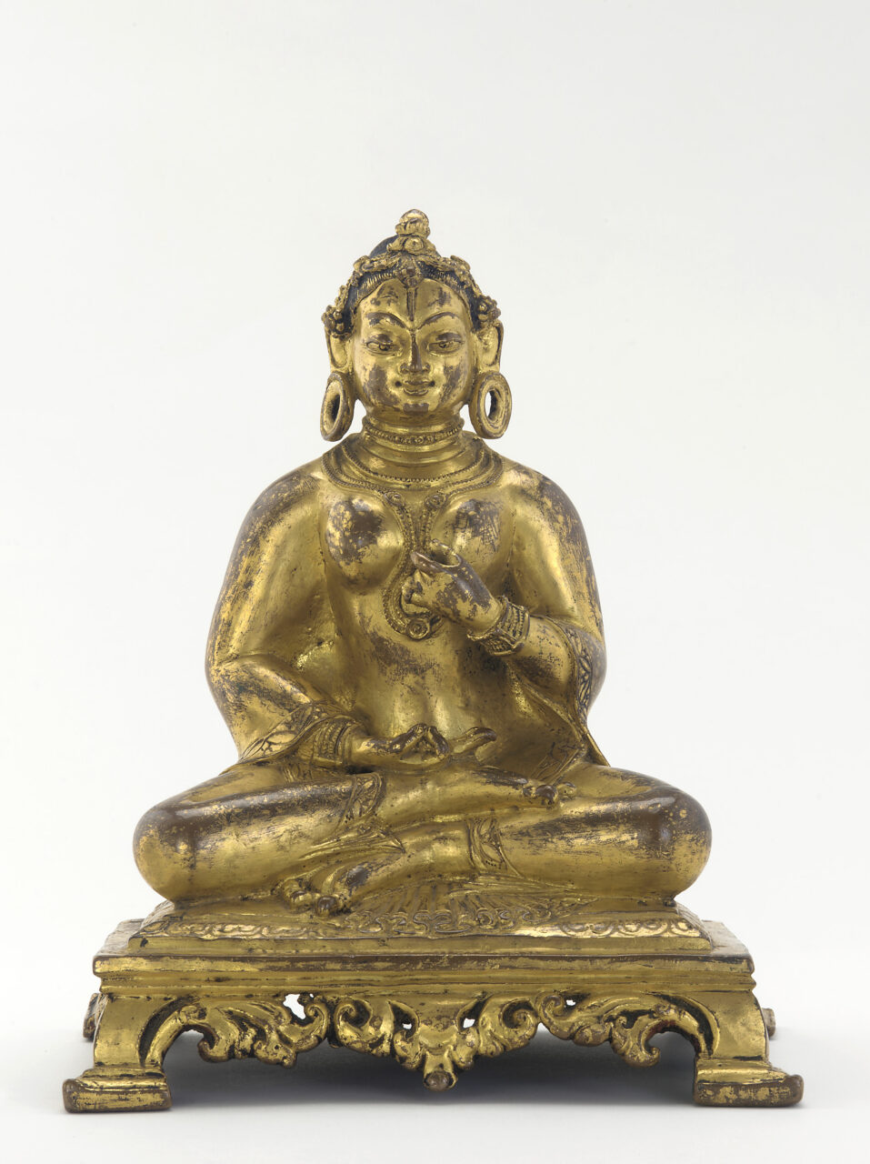Gilded statuette depicting queen wearing diadem, hoop earrings, and thick necklaces; hands posed in mudras