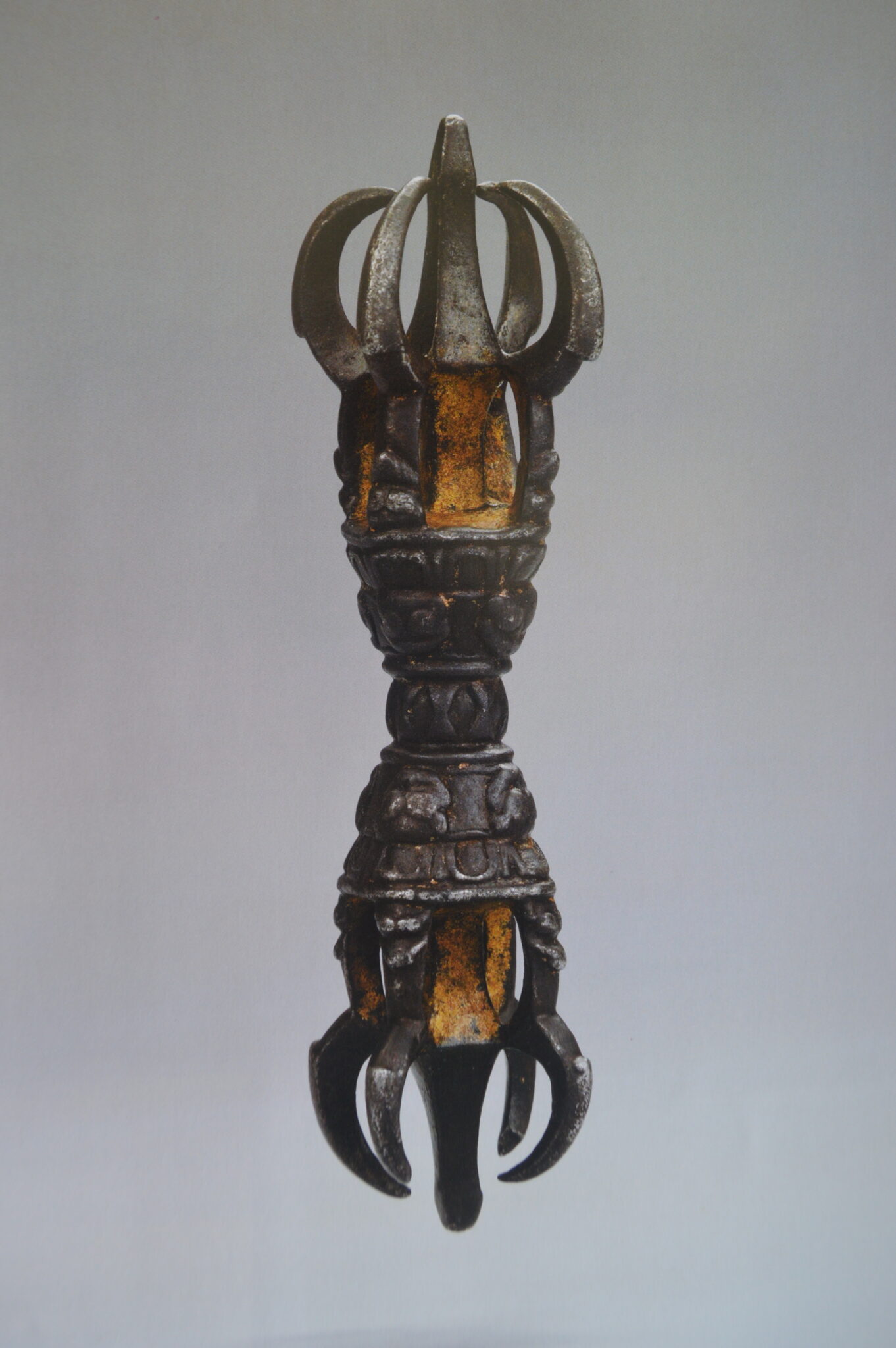 Religious implement in vajra shape: two open spheres formed by curved prongs connected by shaft featuring decorated bands