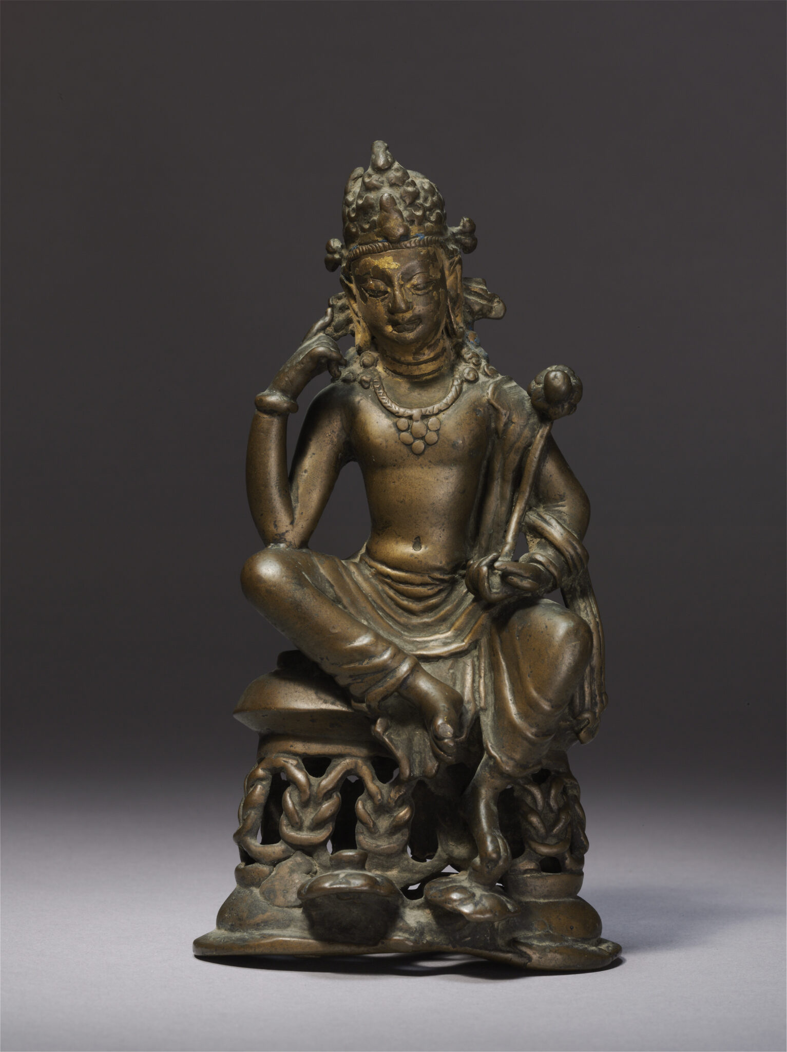 Statuette depicting Bodhisattva, legs half-uncrossed, holding symbolic implement in right hand and left hand raised to cheek
