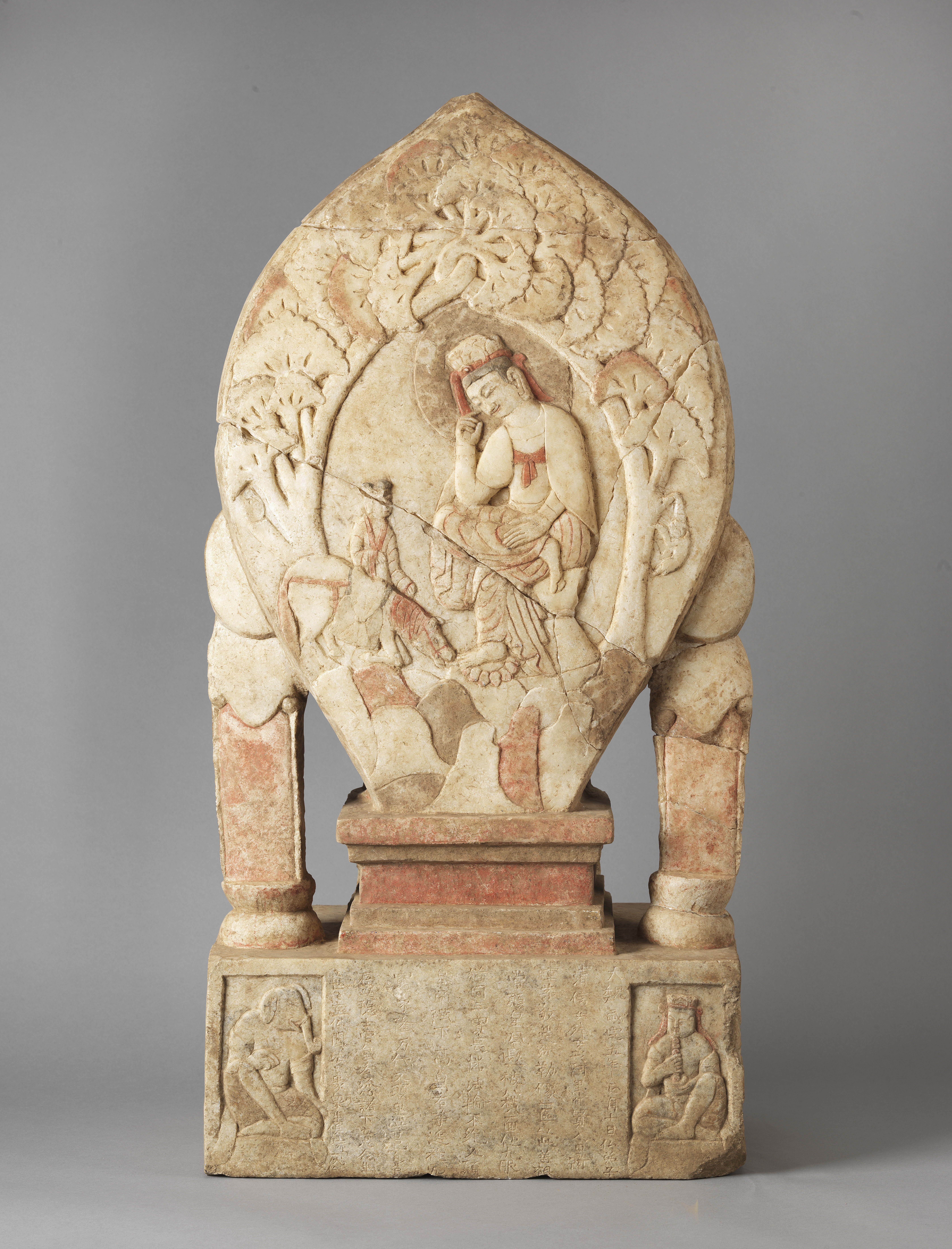 Pinkish-beige sculpture featuring almond-shaped nimbus with Bodhisattva inset; mounted on base and supported by two columns