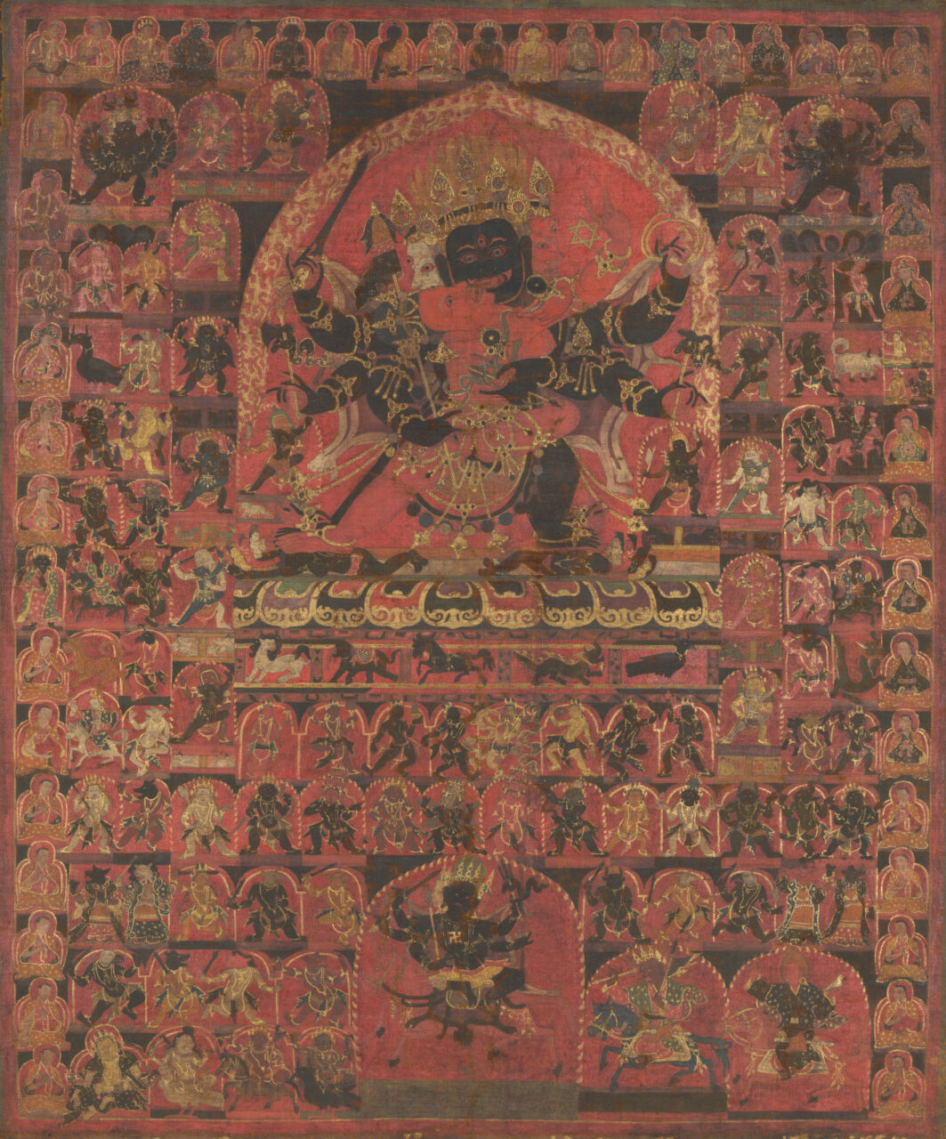 Fearsome deity locked in embrace with consort amid multitude of deity portraits arranged in grid pattern
