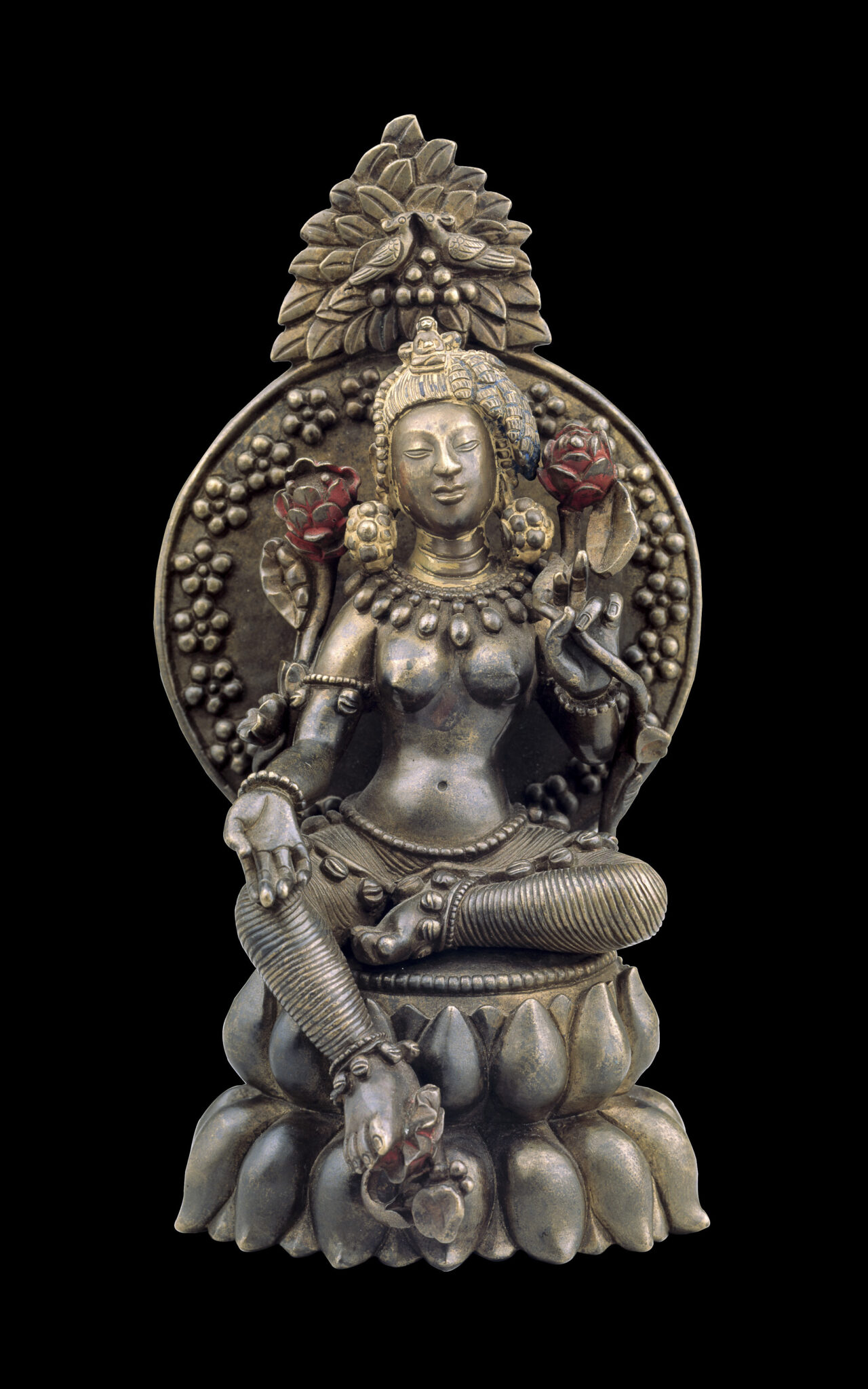 Silver- and brass-colored sculpture depicting bodhisattva, holding red blossoms, seated with left foot extended