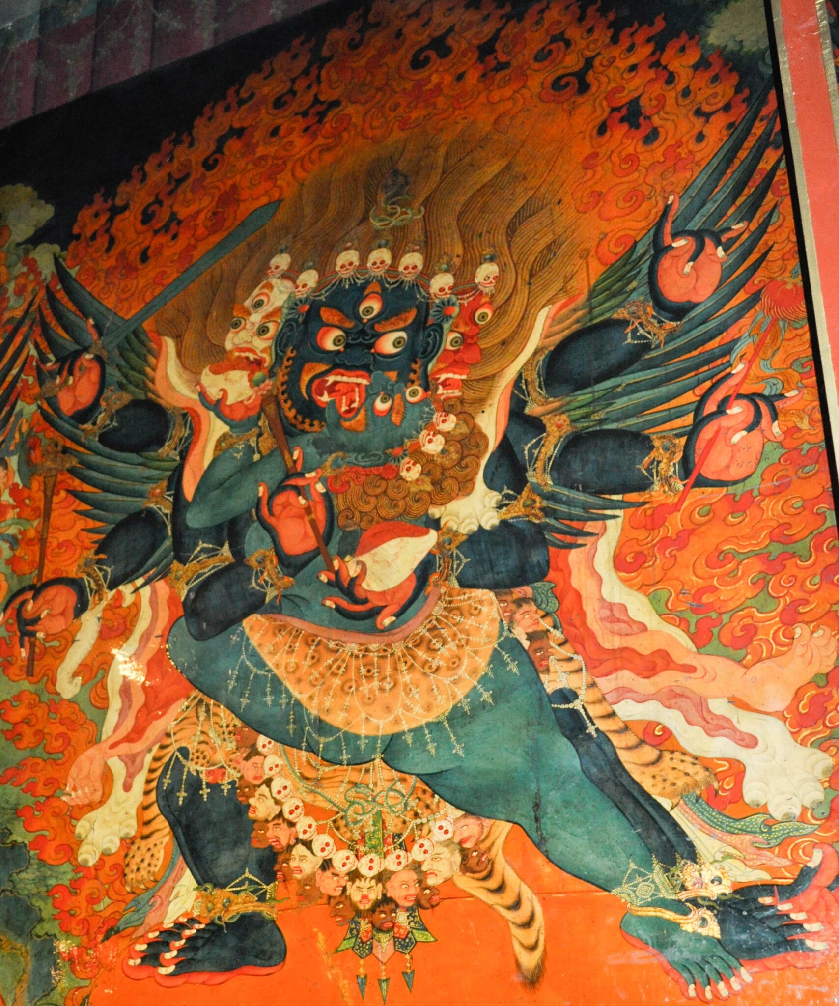 Mural depicting blue-skinned wrathful deity and his consort locked in embrace; both wear skull crowns