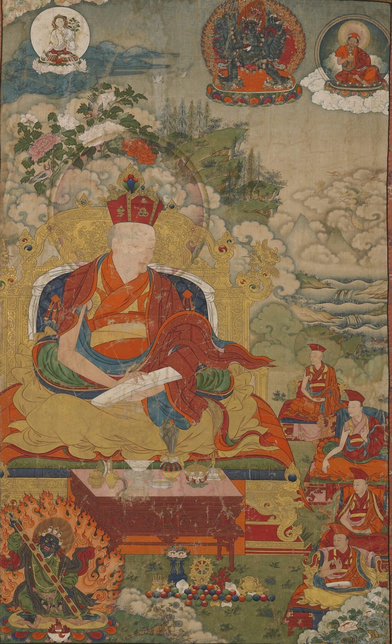Larger than life-size lama seated on golden throne before followers, altar, and wrathful deity