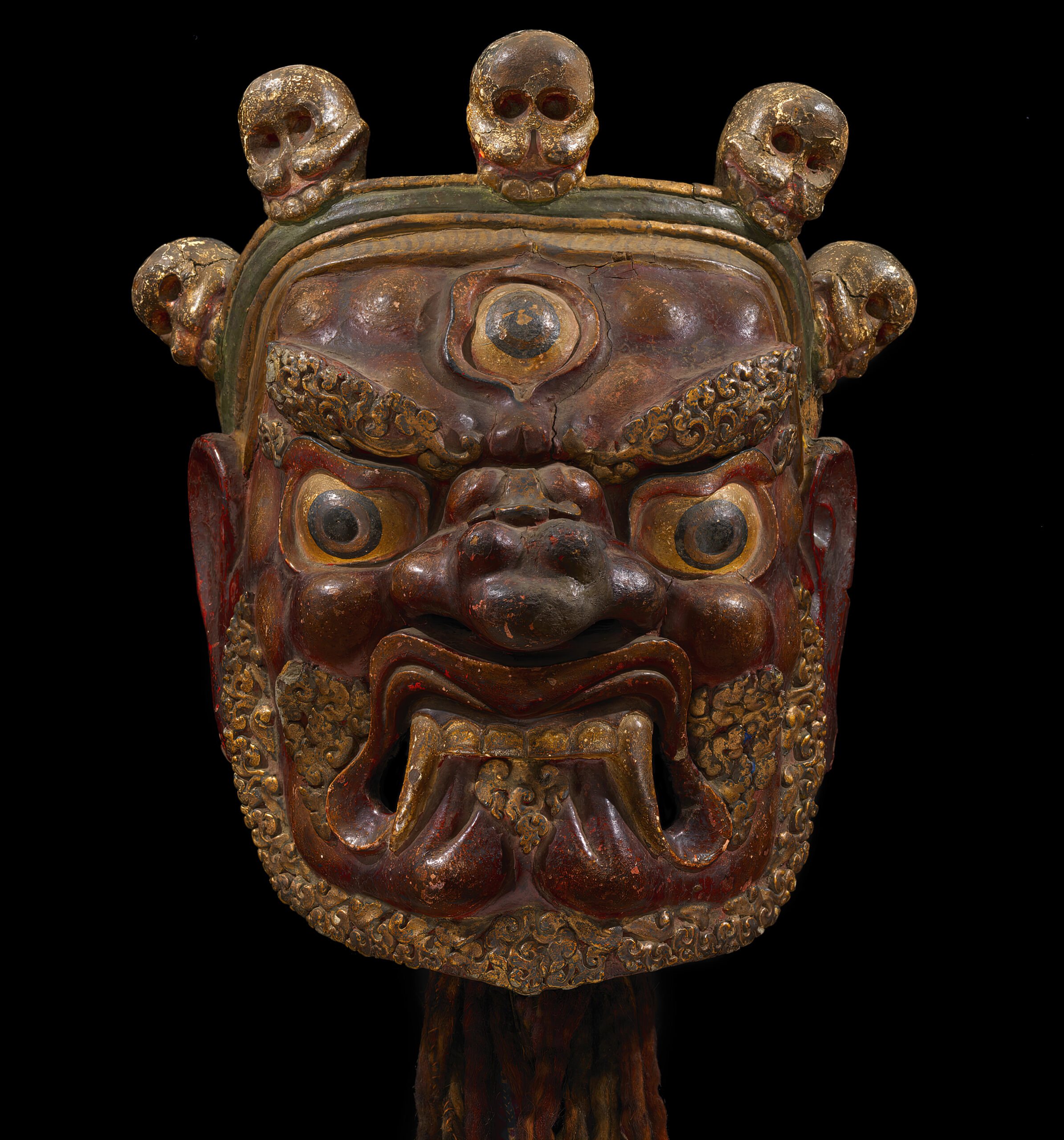 Mask depicting wrathful deity with third eye and bared teeth; features five-skull crown and filigreed beard