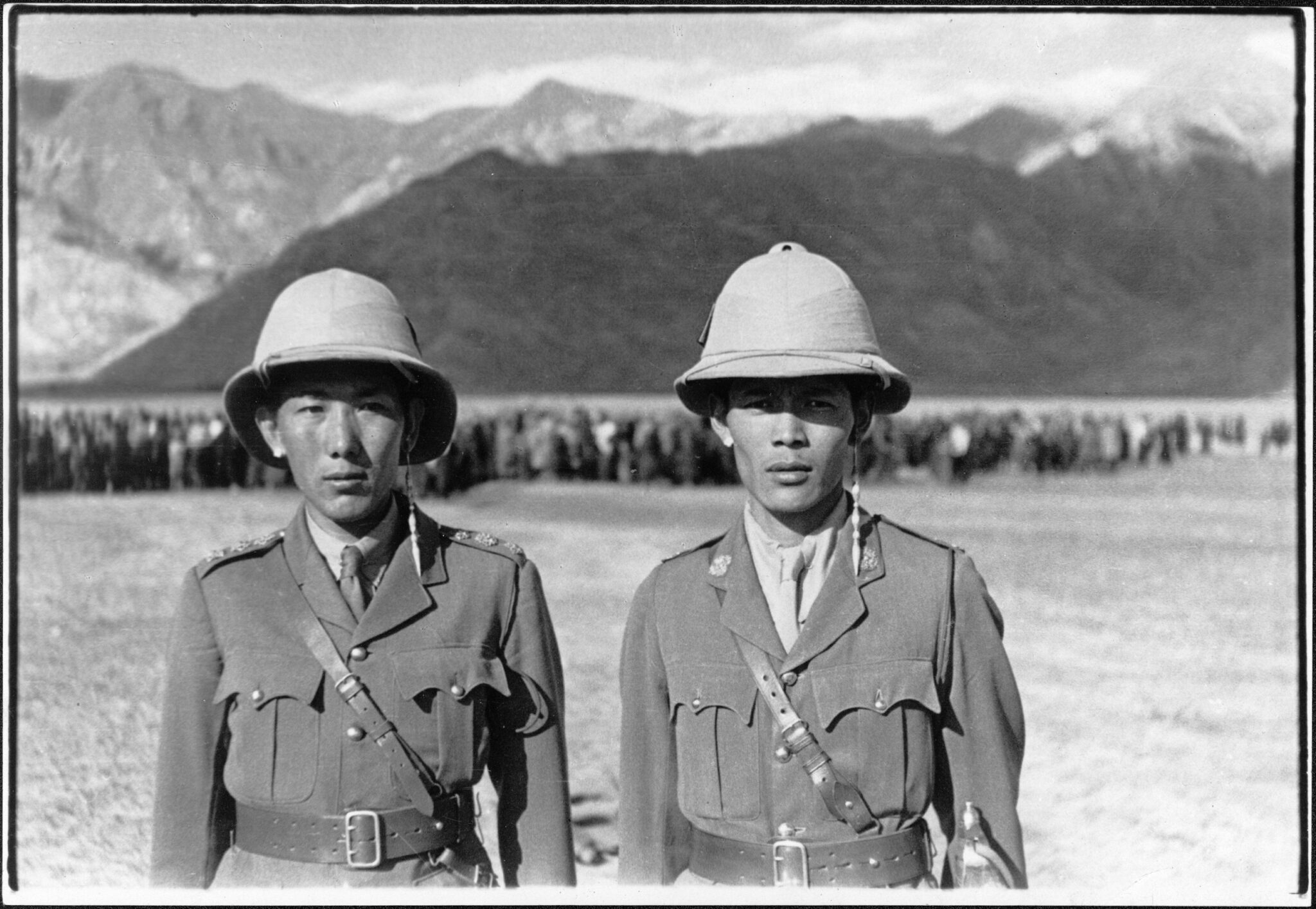 Black and white photograph of two men in military uniform and helmets posing side by side