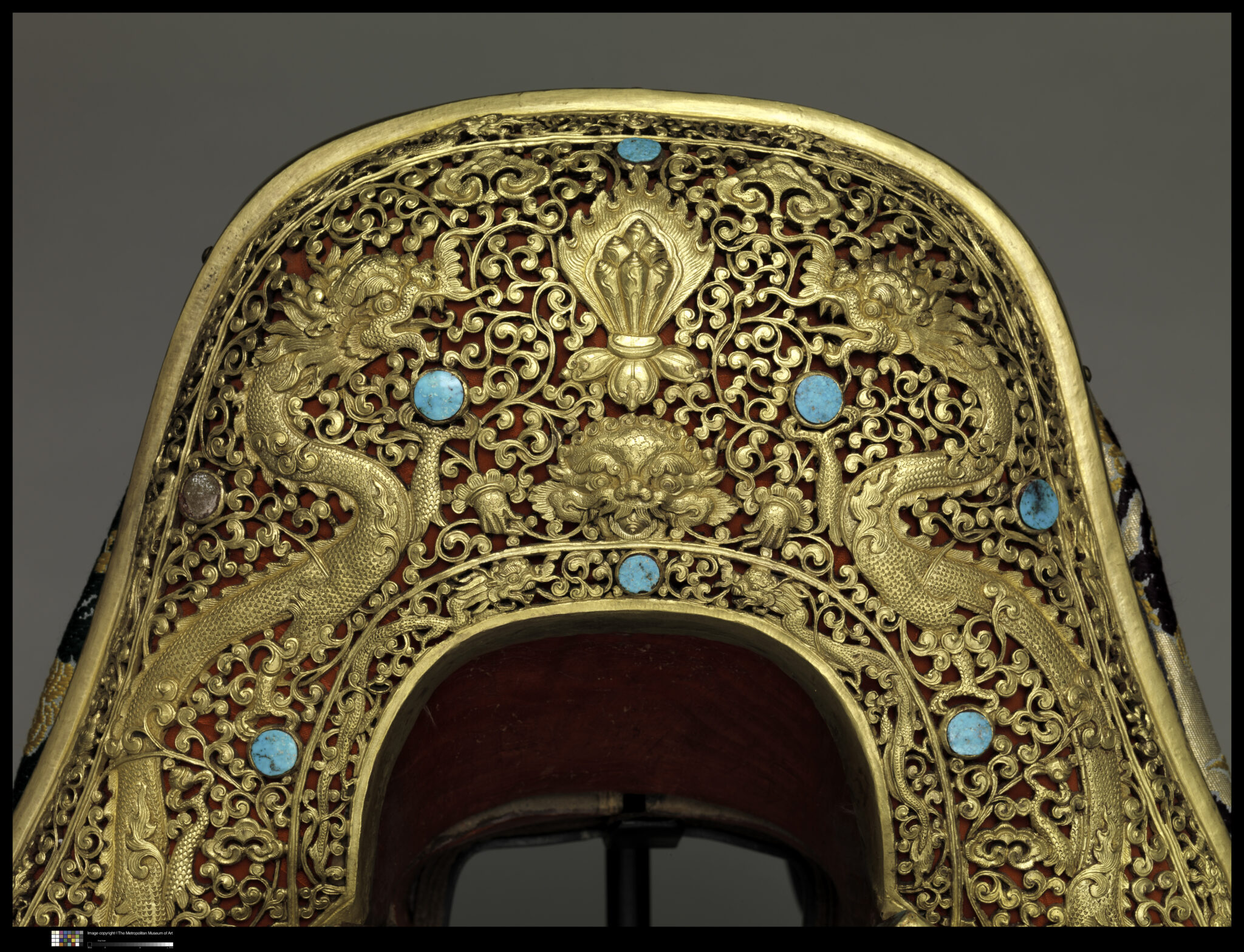 Decoration on front saddle plate depicting dragons writhing and twisting through field of golden filigree scrollwork