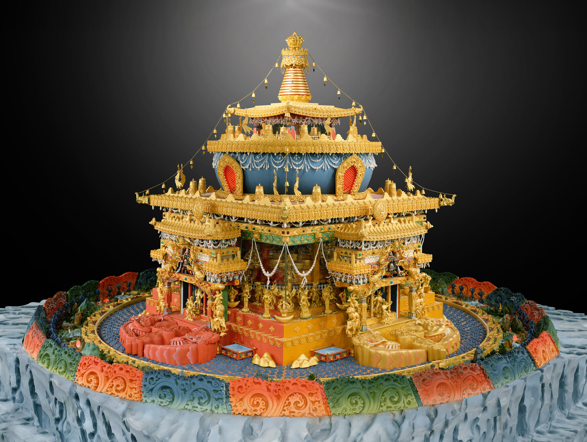 Three-dimensional polychrome mandala in the form of golden architectural structure topped with stupa