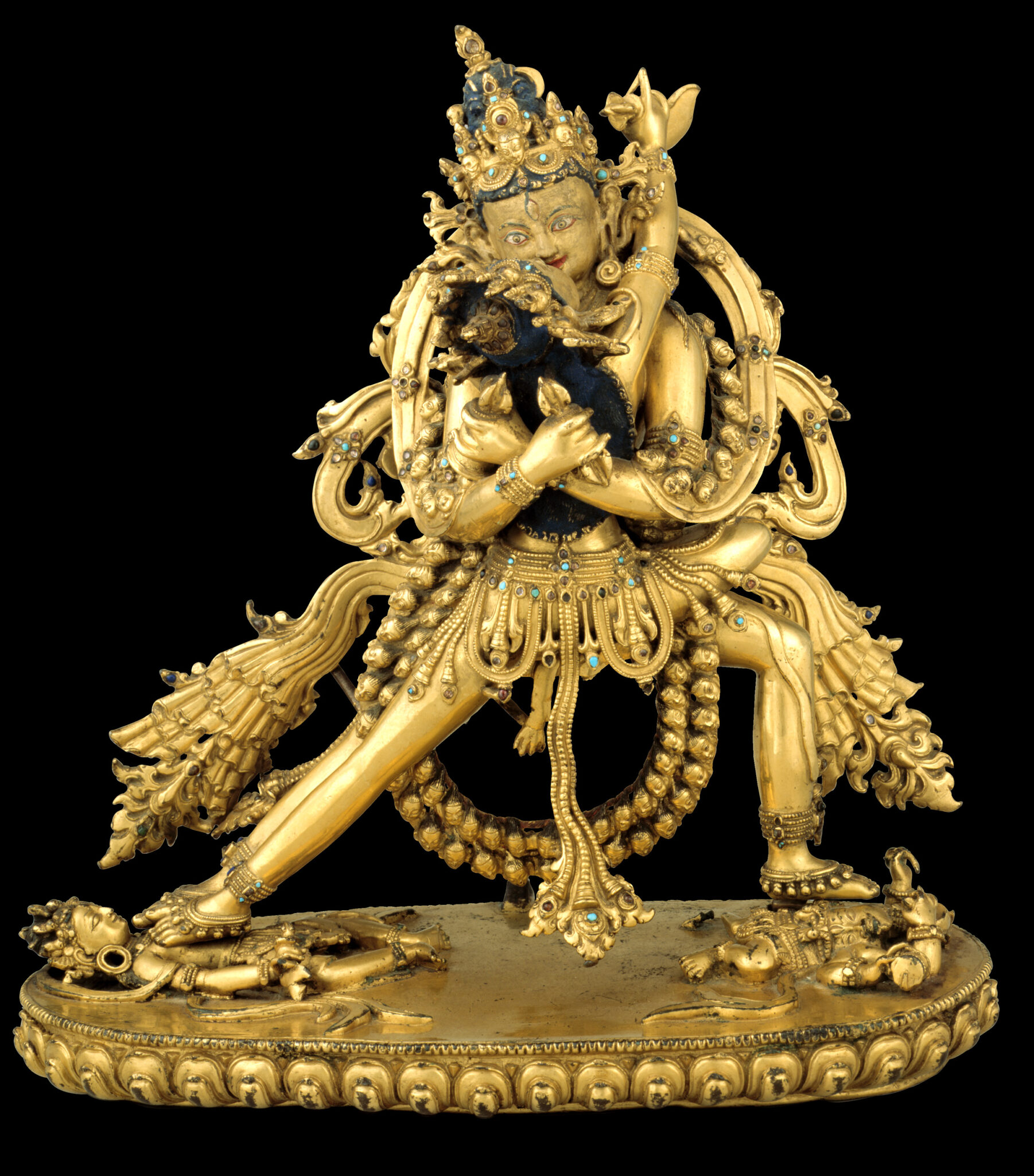 Golden statuette depicting two deities locked in embrace and surrounded by sculptural, billowing sashes
