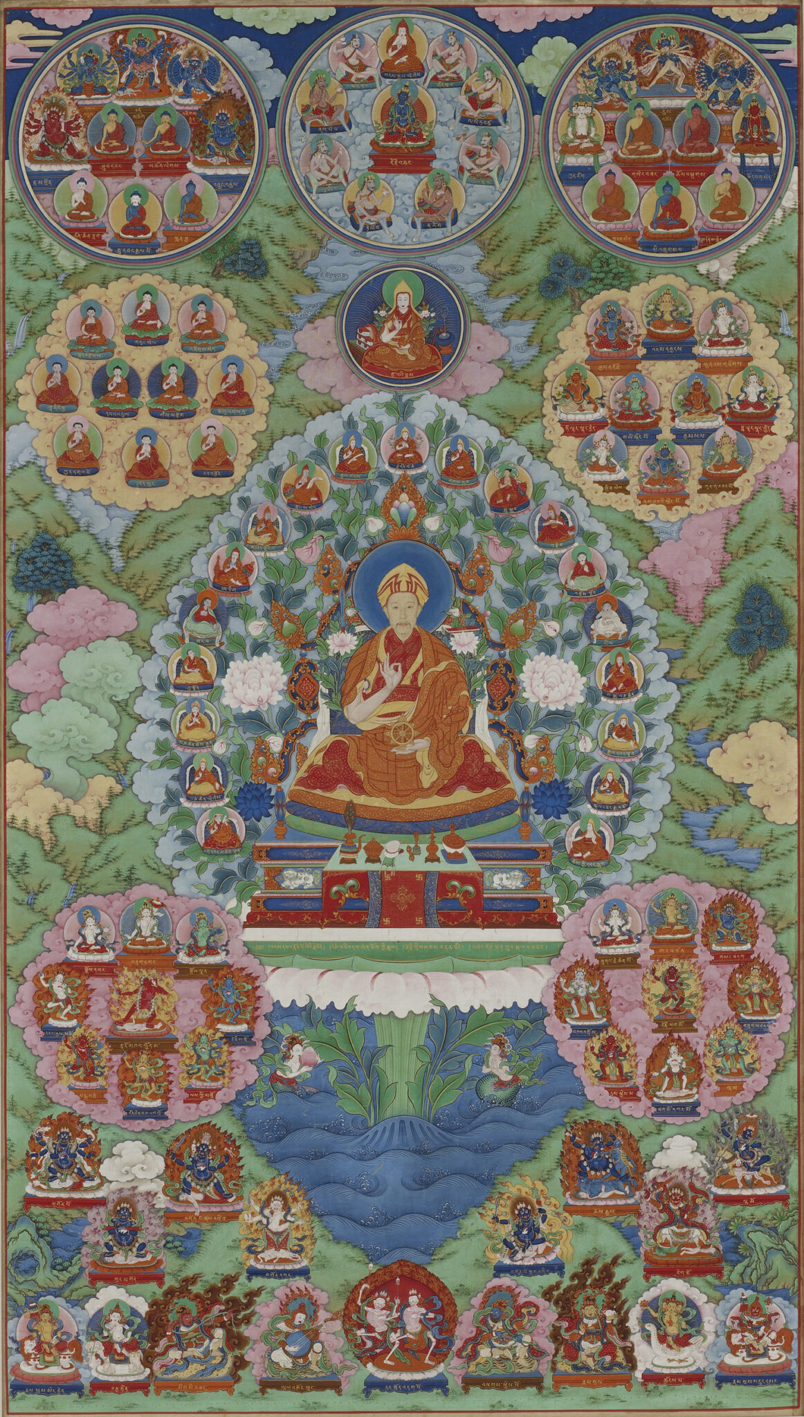 Hovering above mountainous landscape, four roundels inset with portraits surround central image of saffron-robed figure
