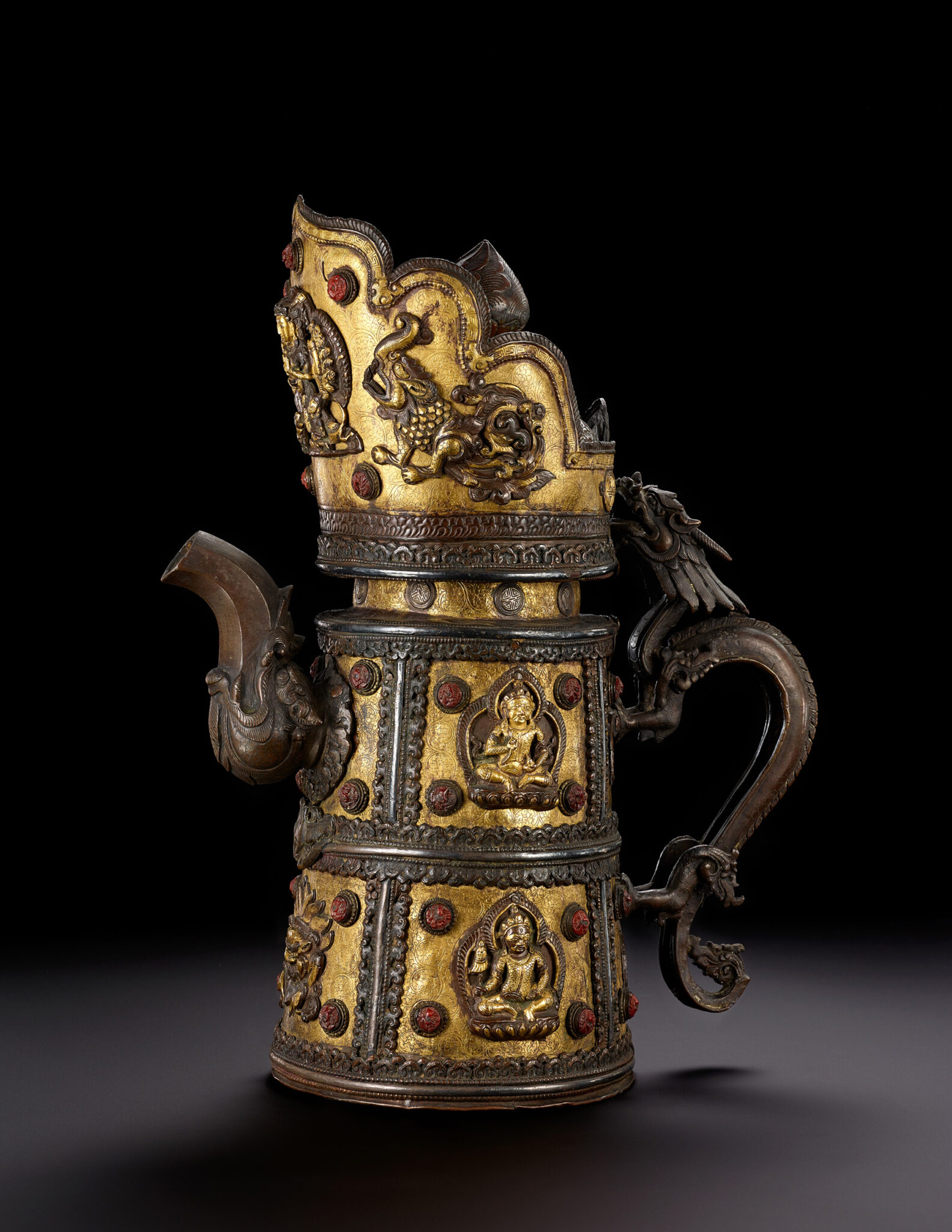 Golden and brown metal pitcher decorated with panels depicting seated figures and topped with bodhisattva-crown form