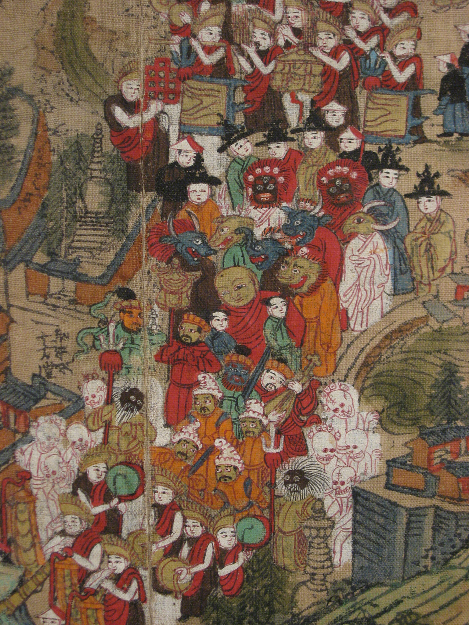 Procession of monks playing musical instruments and figures wearing pointed hats and fantastical, macabre masks