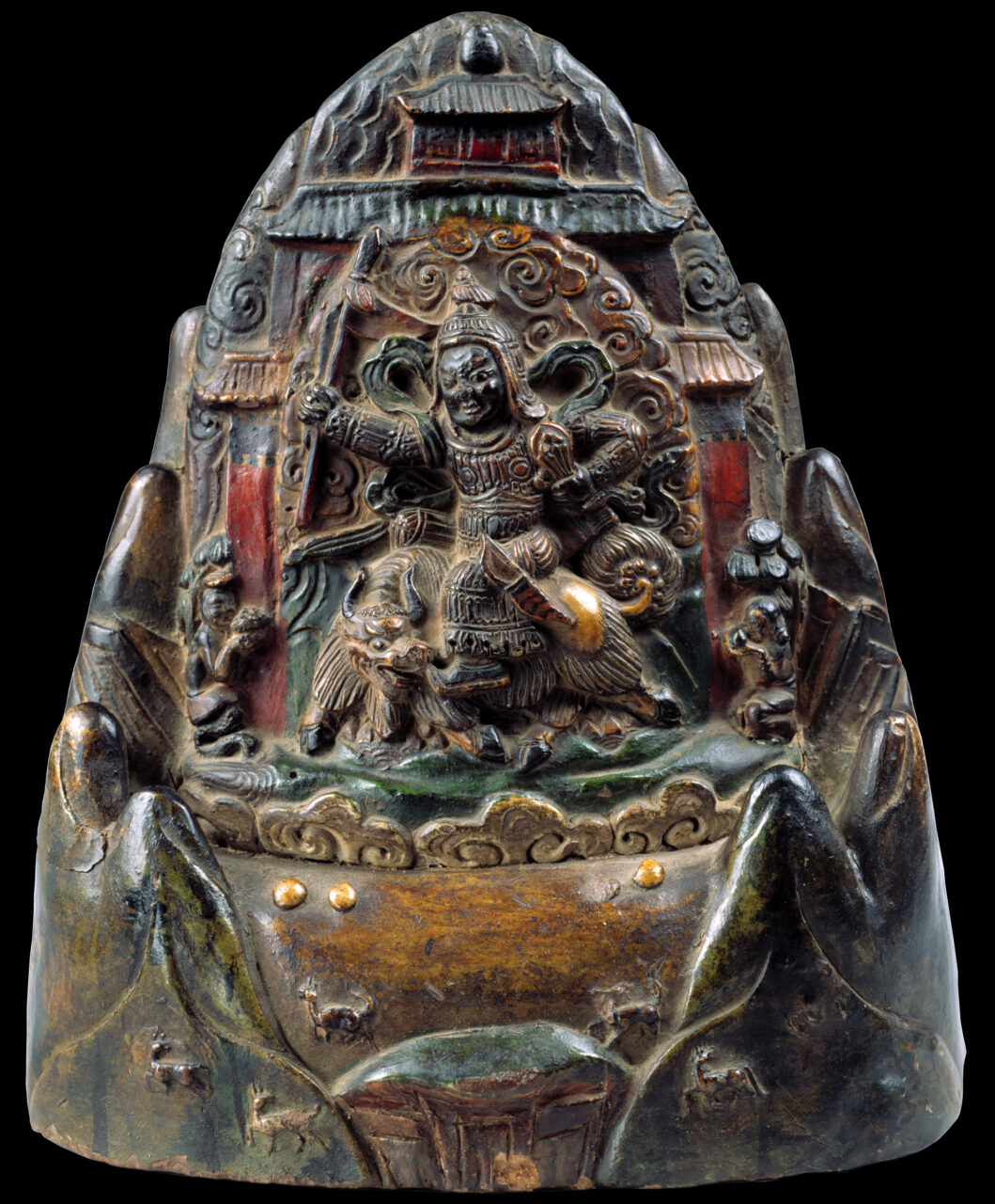 Polychrome sculpture depicting deity riding on yak before pagoda situated between mountain peaks