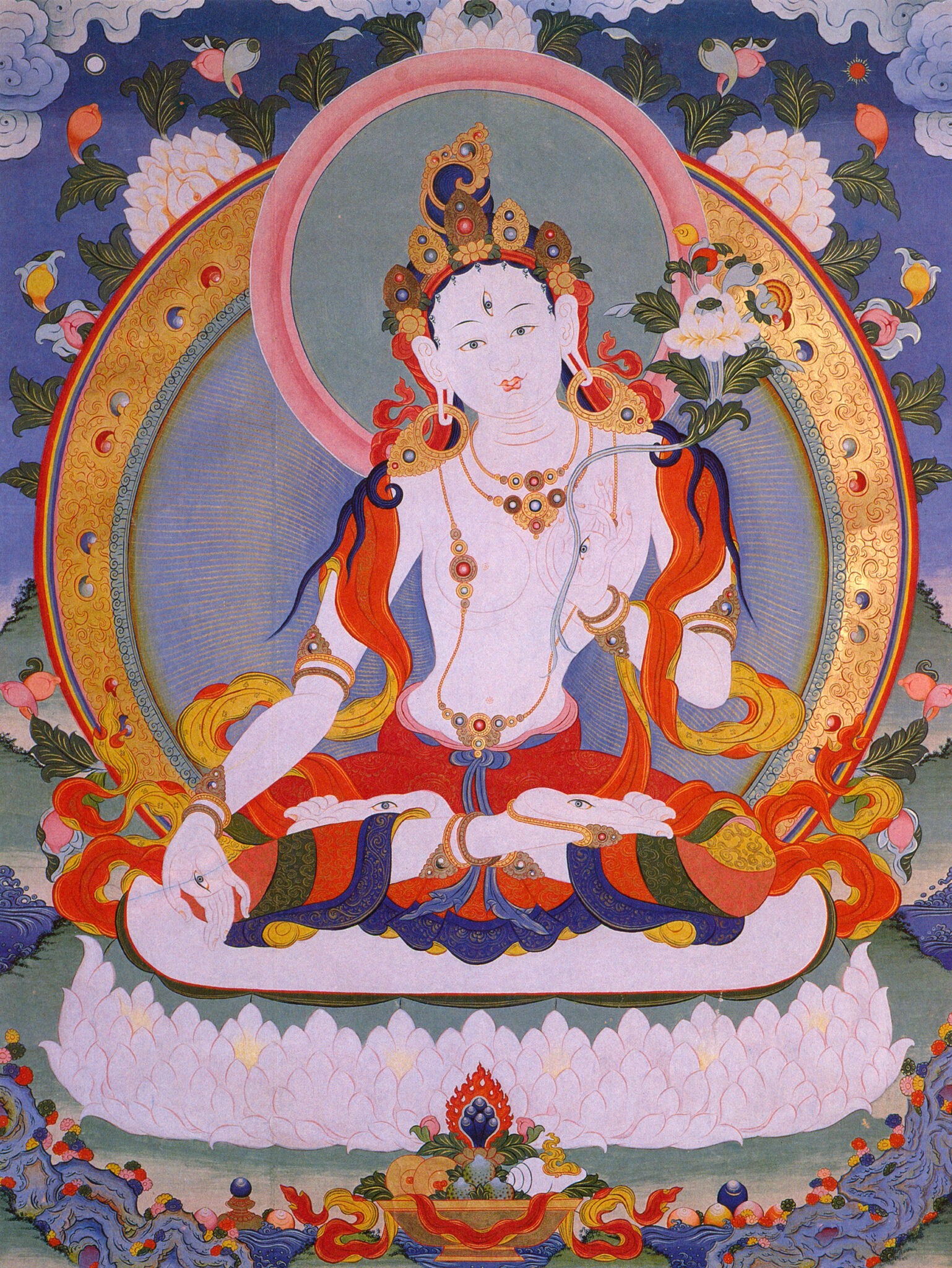 Seated deity poses left hand in mudra at knee and holds blossom in right hand