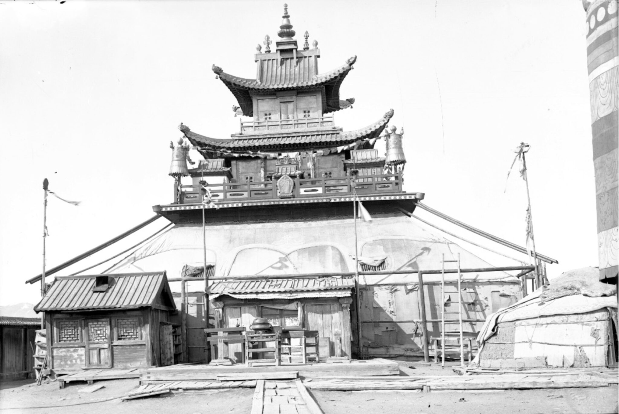 Black and white photograph of three-story temple with broad base, pagoda roofs, and ornate balustrades and finials