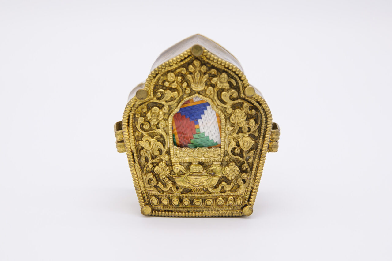 Golden nimbus-shaped box; features floral scrollwork around border and inset textile square with blue, white, green, and red quadrants