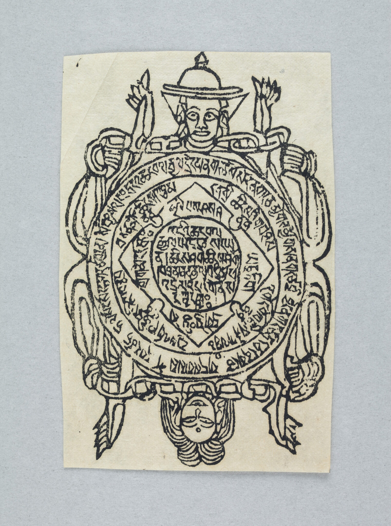 Line drawing in ink depicting central circle inscribed with text framed by two figures; One upside down, one right-side up