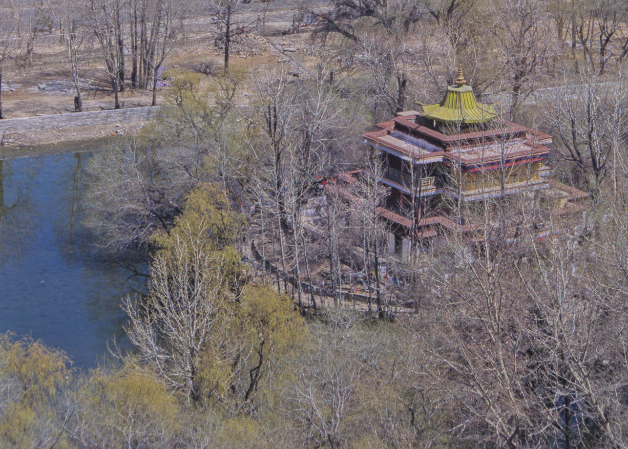Temple in the form of three-dimensional mandala situated on circular island amidst trees in the springtime