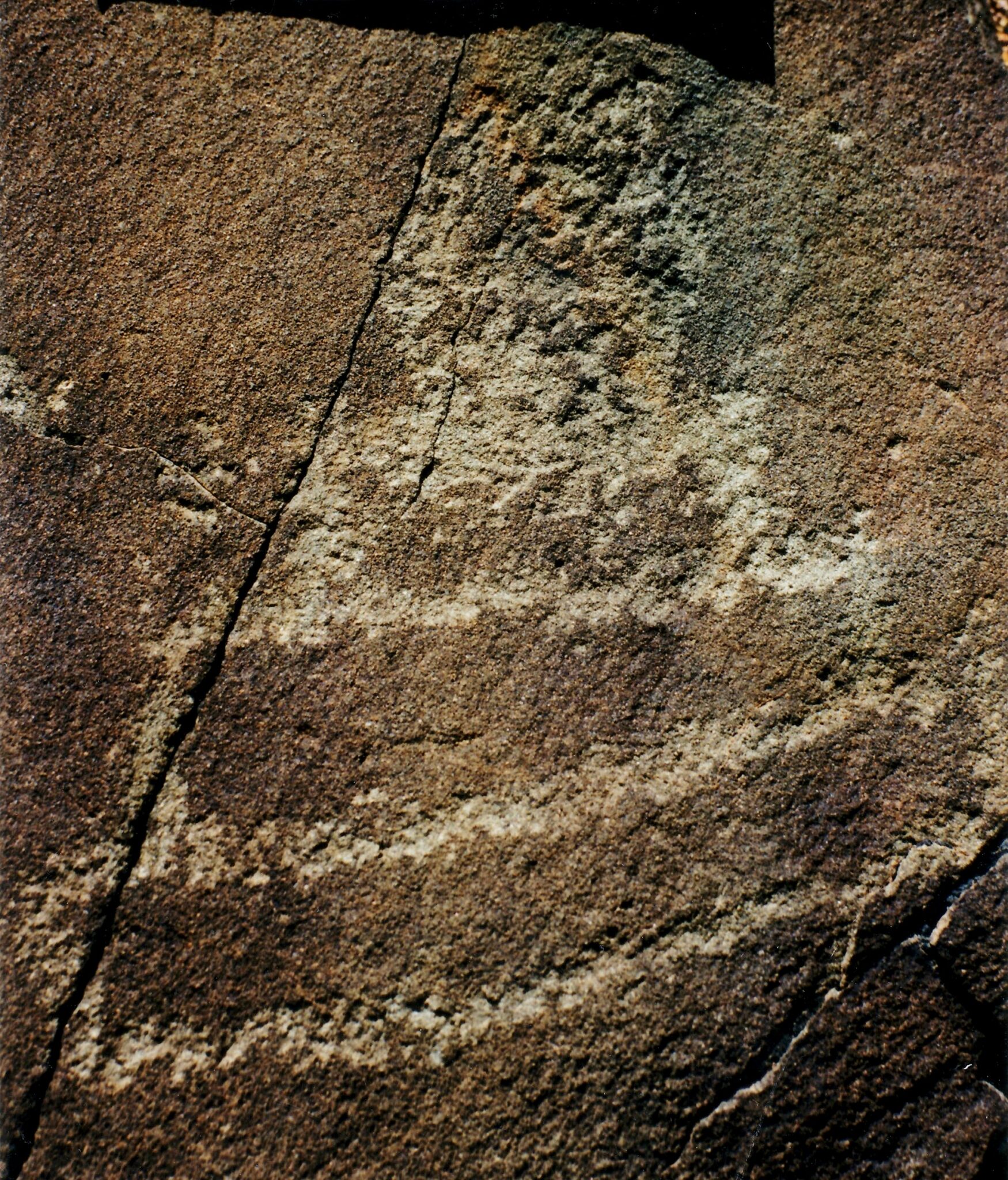 Carving on cracked stone of three stacked rectangles of decreasing width topped by roughly circular form