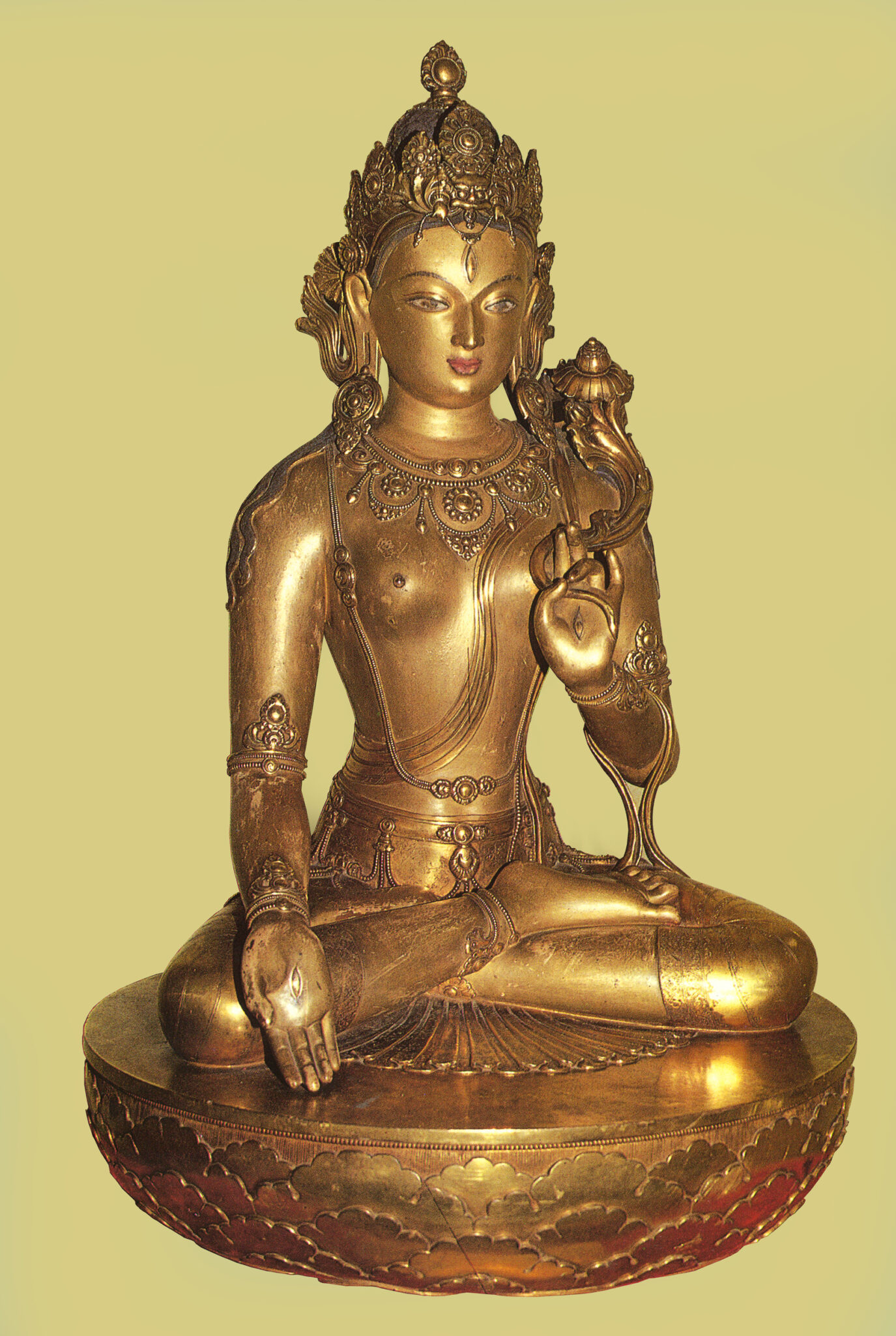 Golden statue depicting Bodhisattva sitting cross-legged, left hand at knee, holding implement in right