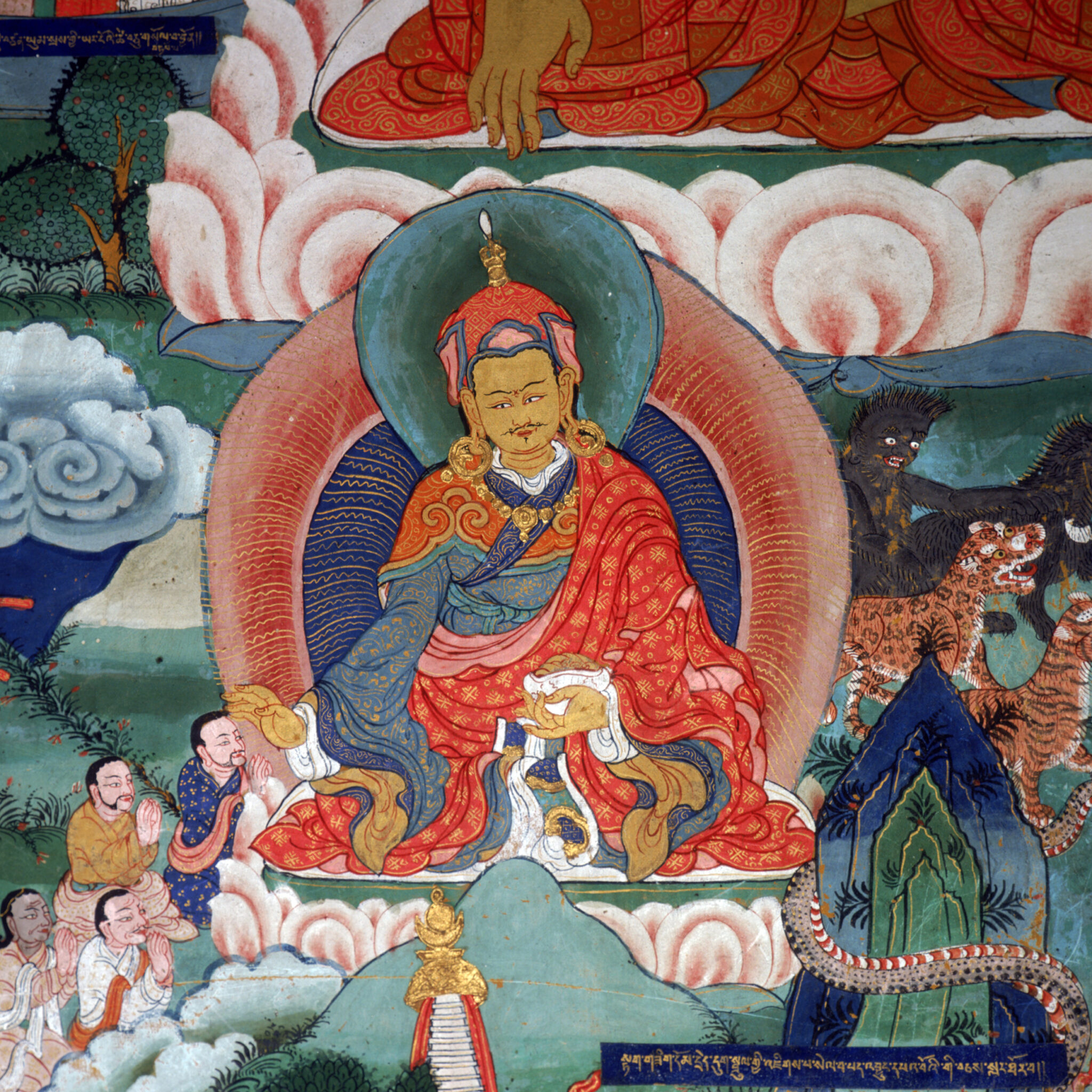 Guru wearing gold and red brocade robe flanked by attendants at left, herd of animals at right