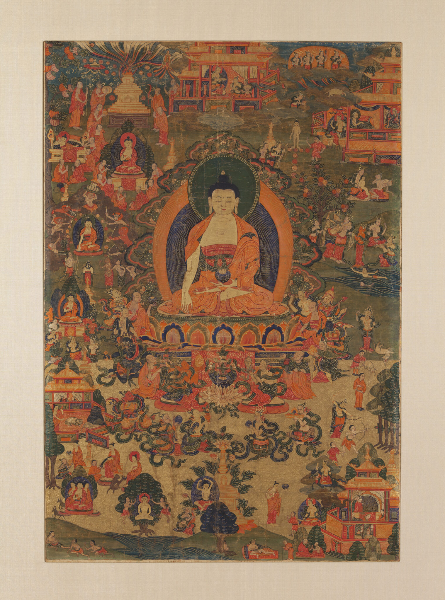 Buddha hovers, left hand extended towards ground, above landscape dotted with buildings and groups of figures