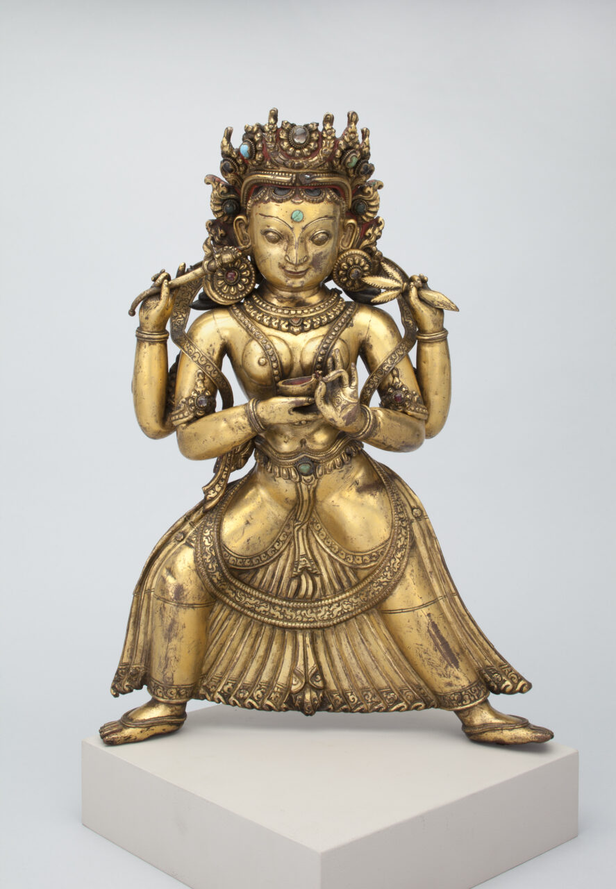 Golden statue depicting crowned four-armed goddess of war standing in dynamic position