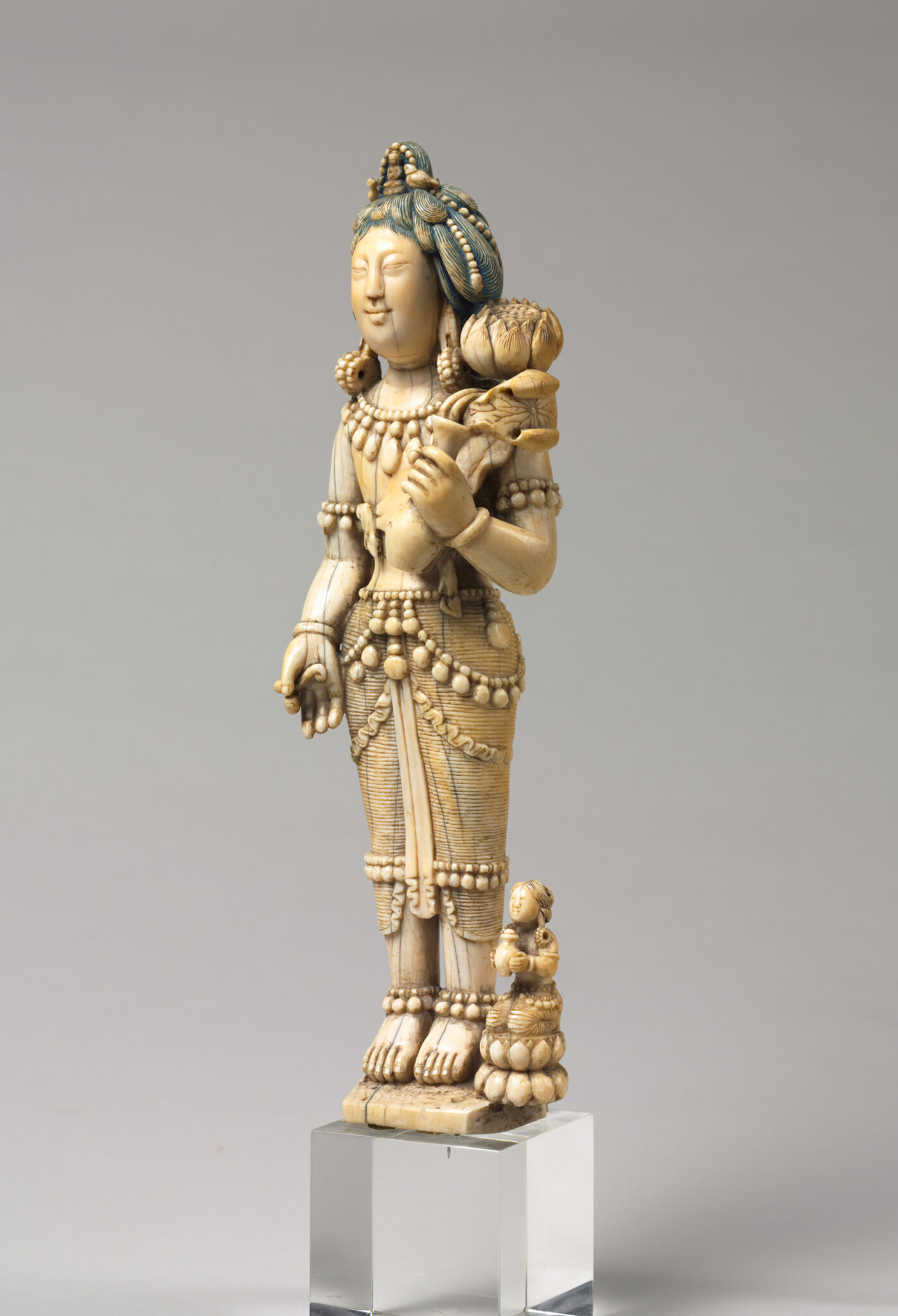 Three-quarter profile view of ivory statuette depicting Bodhisattva wearing finely articulated dhoti and accessories