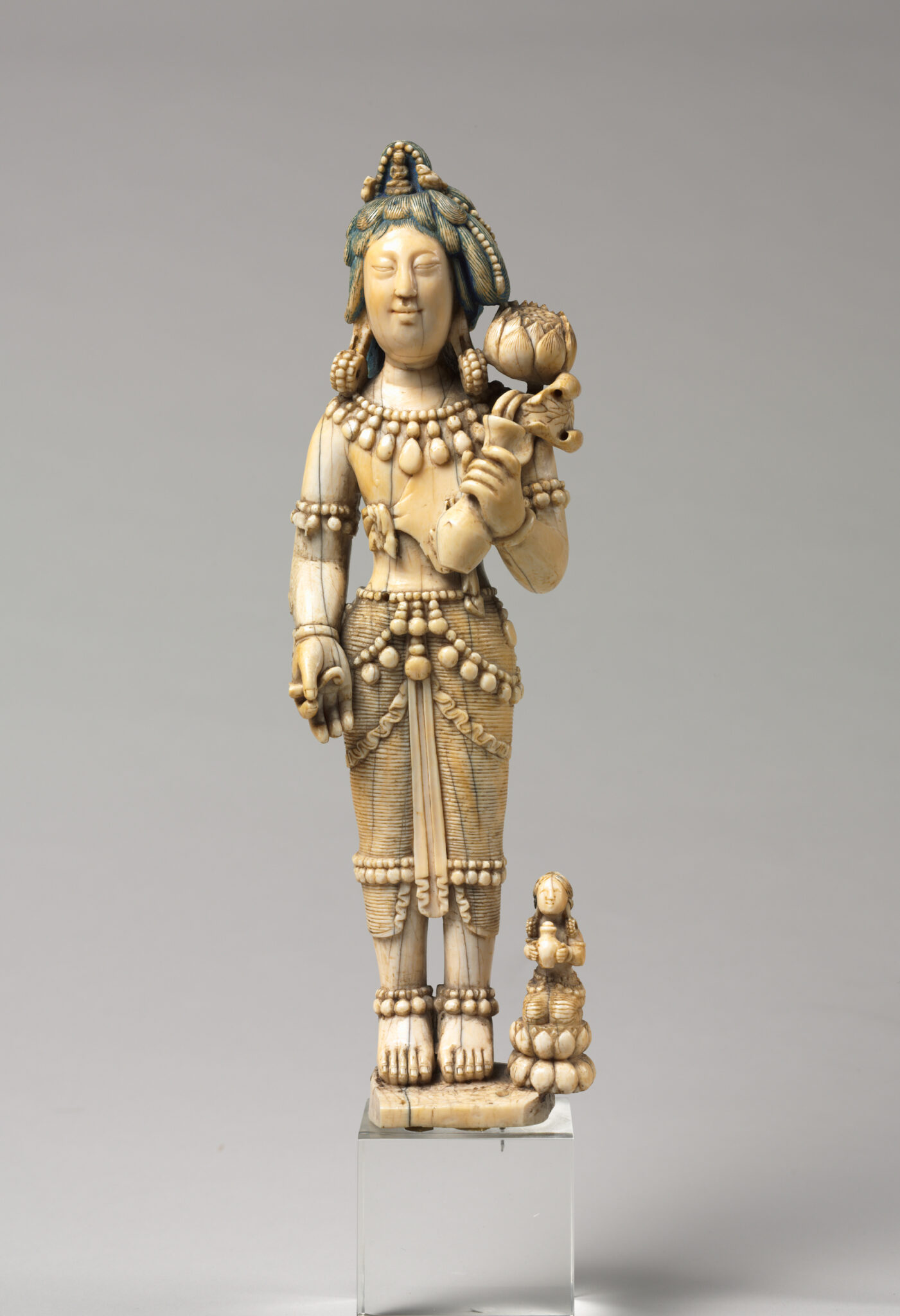 Ivory statuette depicting Bodhisattva wearing finely articulated dhoti and accessories holding blossom in right hand