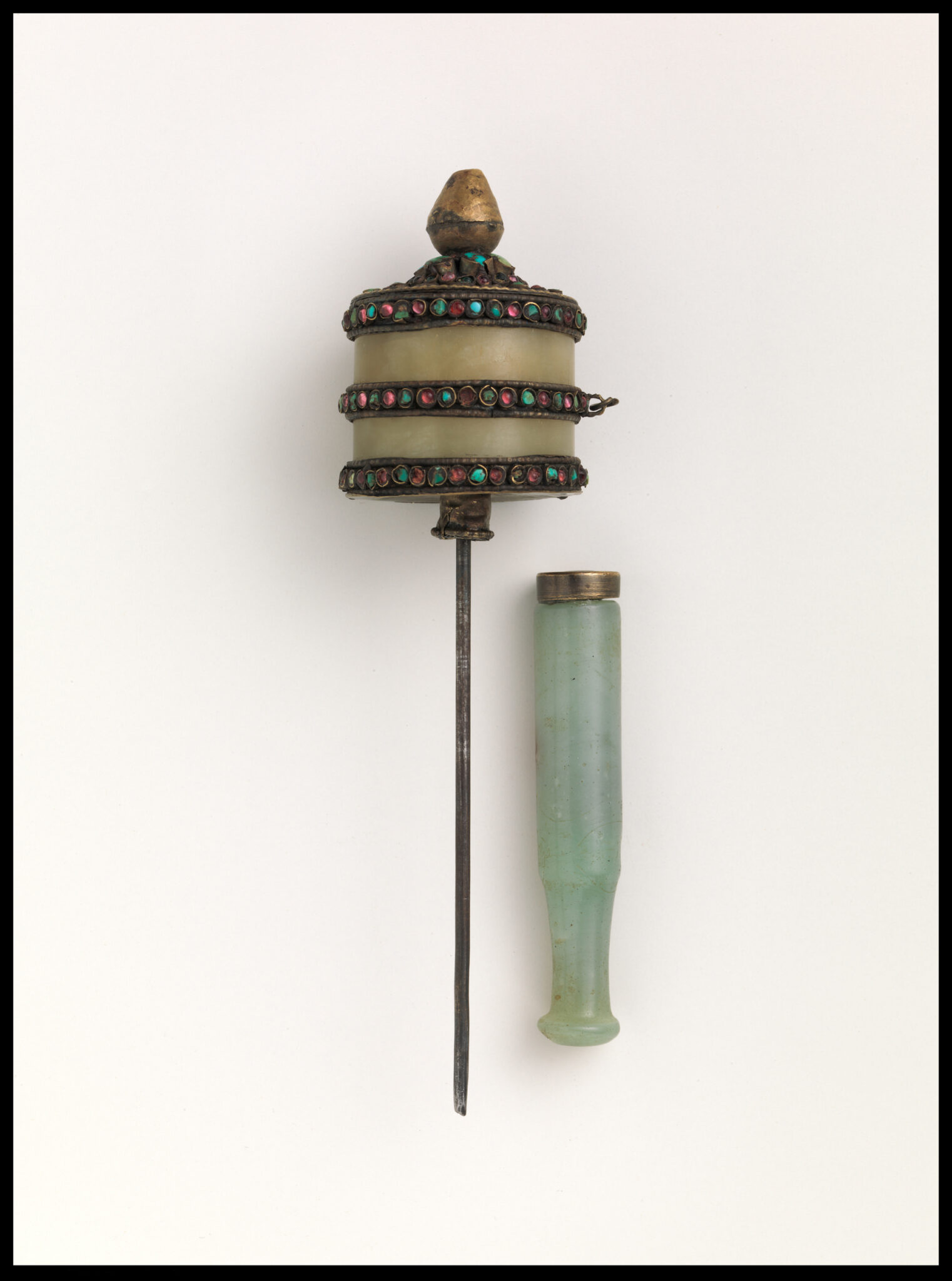 Glass cylinder featuring three stone-decorated bands mounted on spindle; green jade handle at right