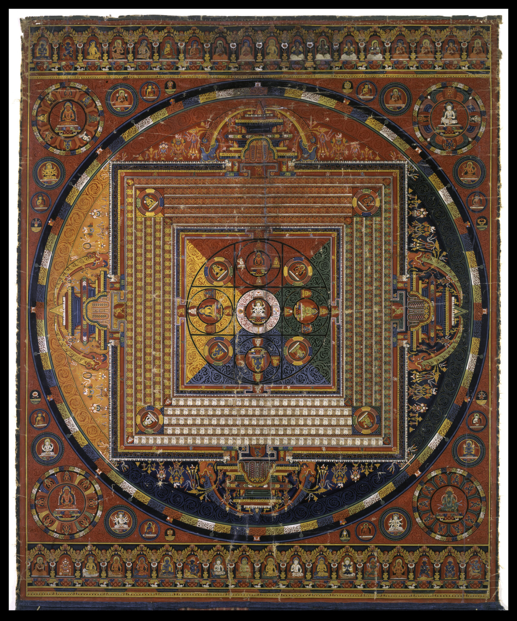 Mandala featuring yellow, red, green, and blue quadrants; arched registers at top and bottom feature miniature seated figures
